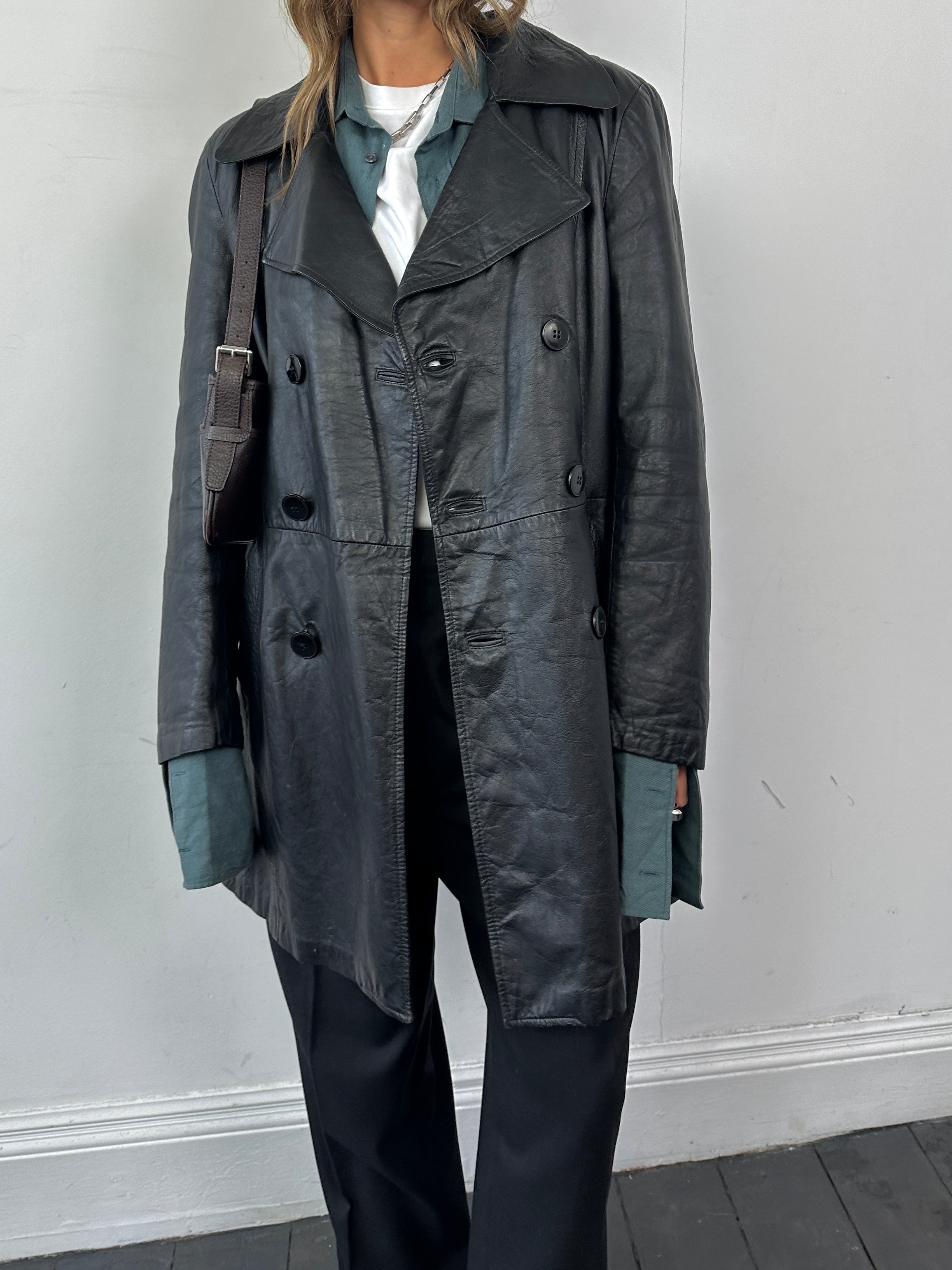 Vintage Italian double-breasted leather jacket in mid-length style, featuring classic design and worn-in leather appearance.
