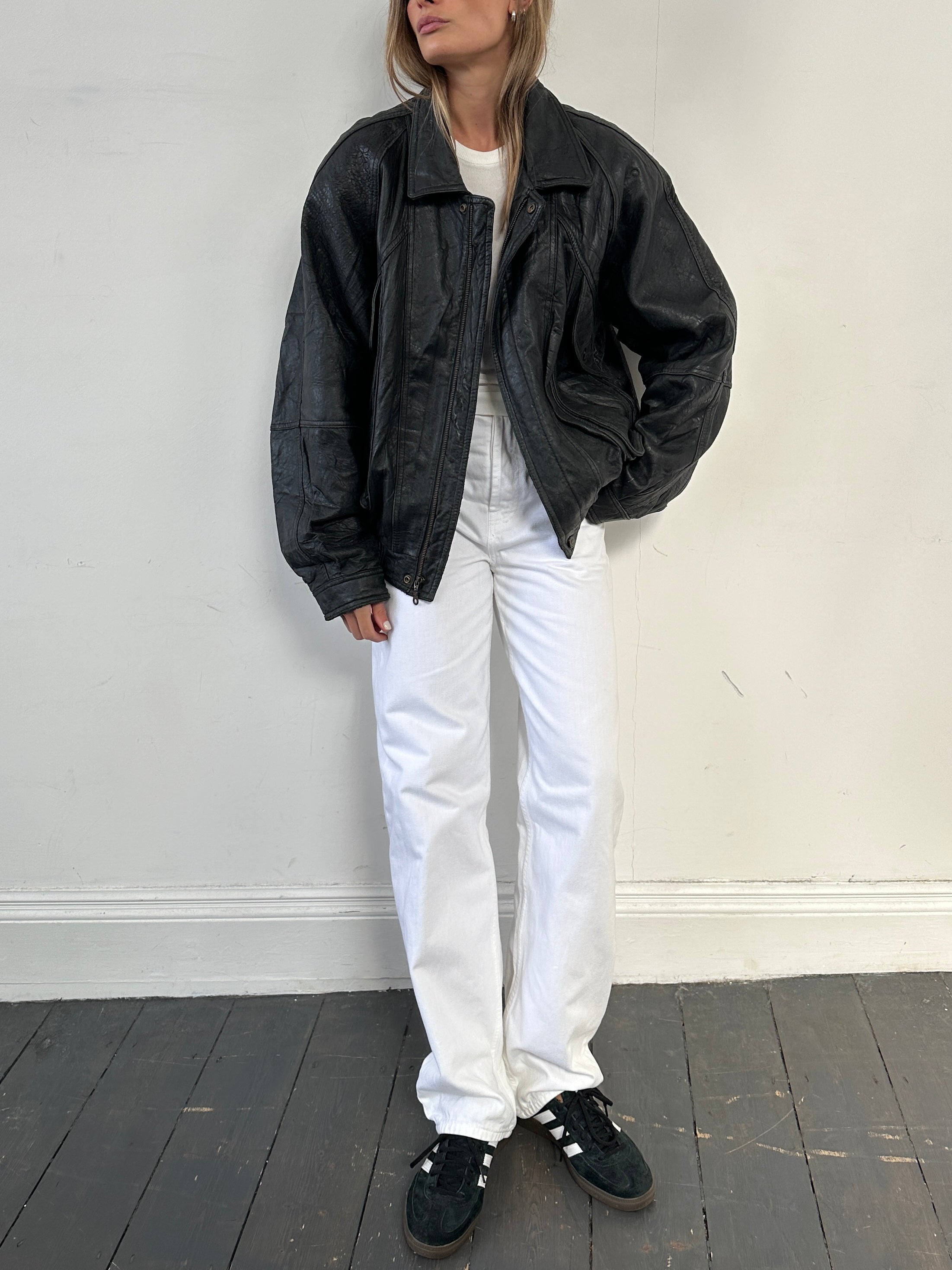 Vintage distressed leather bomber jacket in size large, featuring a rugged design and classic collar, displayed on a hanger.
