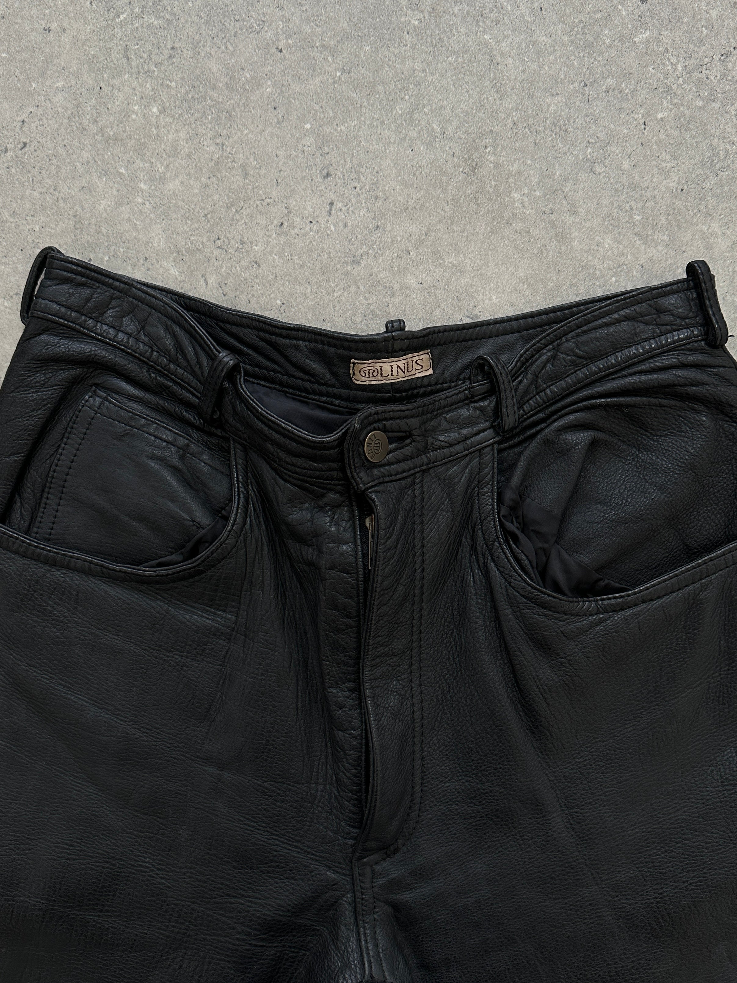 Vintage high waisted straight leg leather trousers in W28, showcasing a classic fit and smooth leather texture.