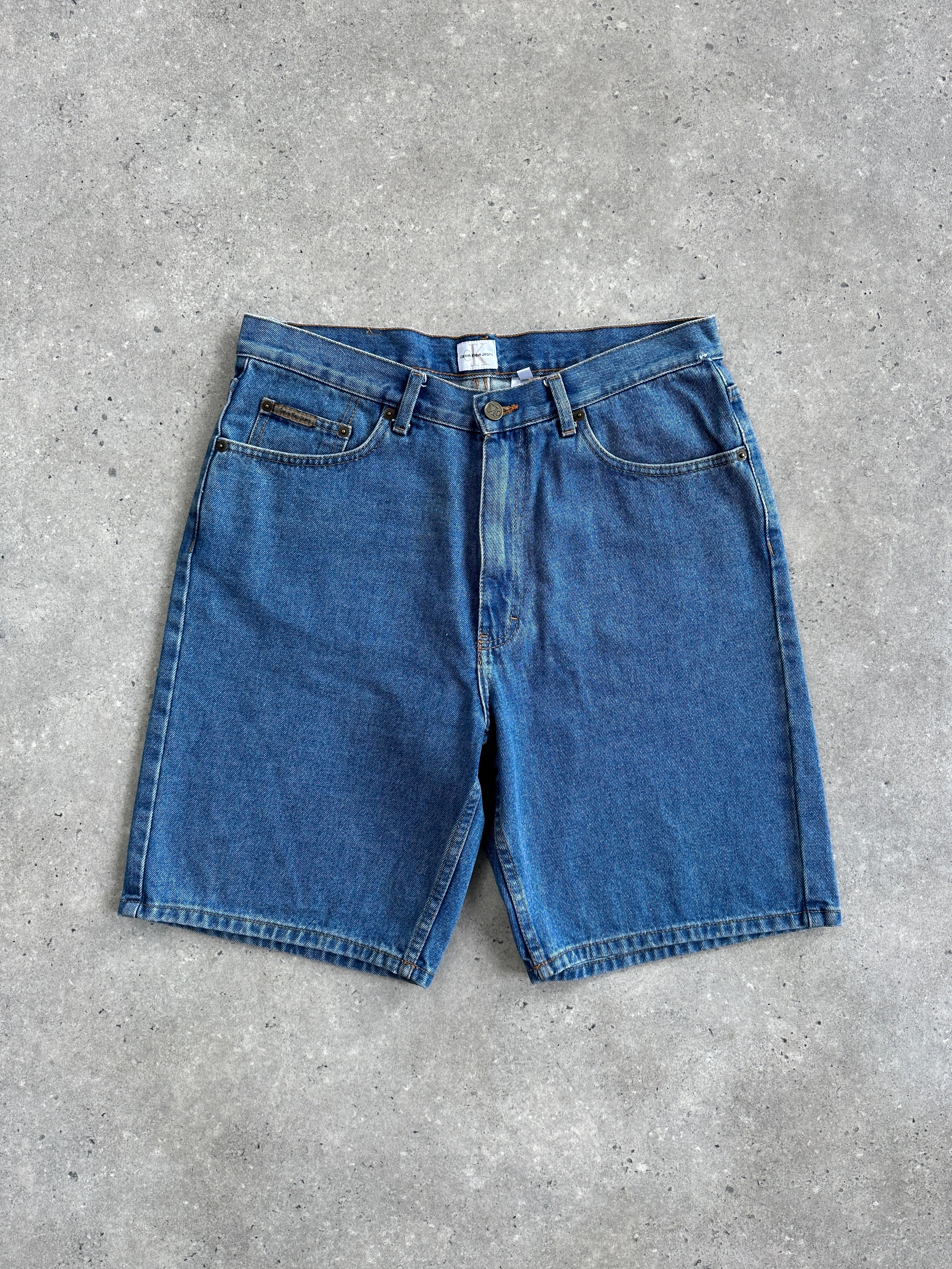 Calvin Klein CK loose leg denim shorts in W32 style, featuring classic blue wash and relaxed fit, displayed on a plain background.