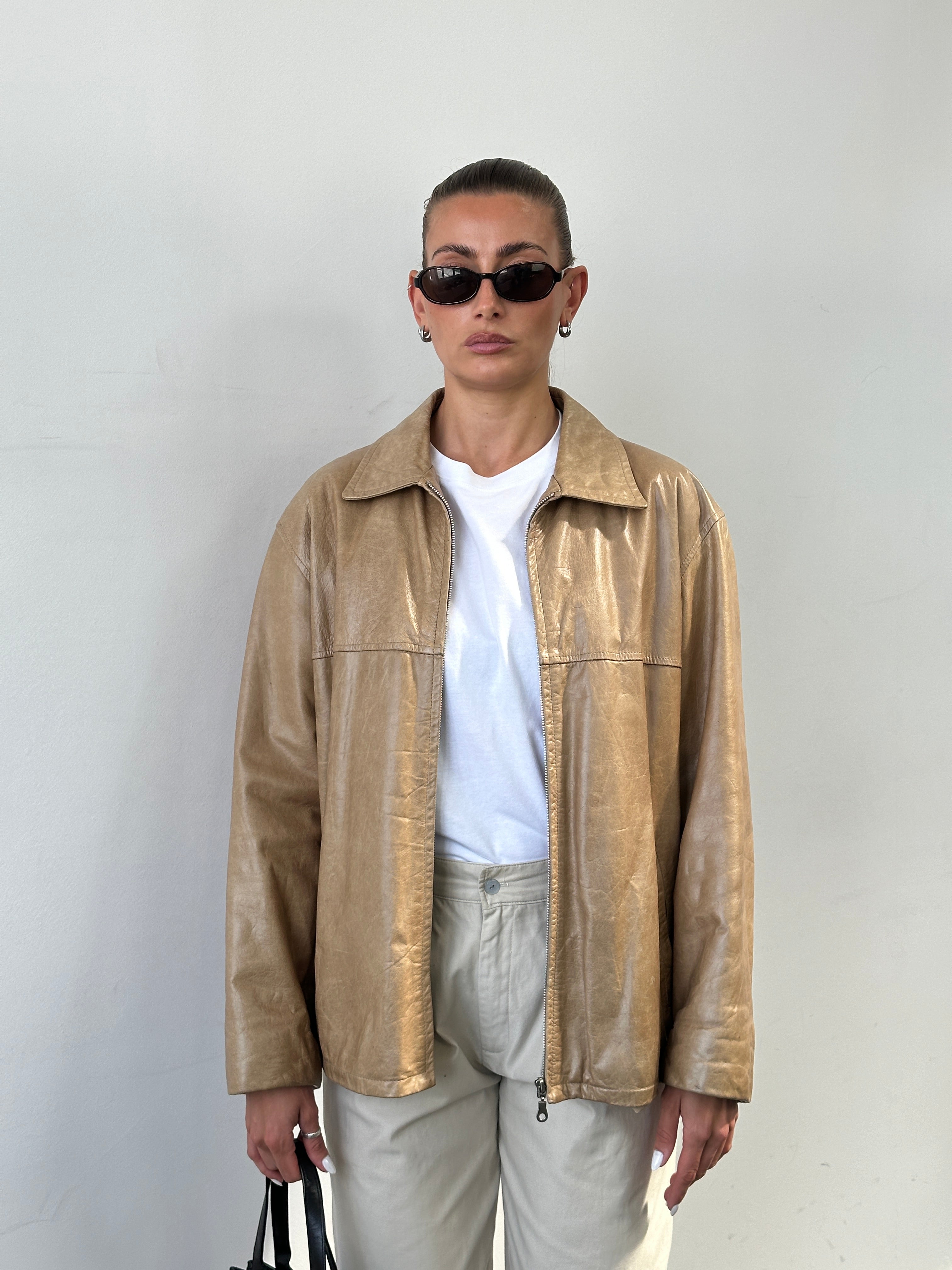 Italian vintage minimal leather jacket in size L, featuring sleek design and classic craftsmanship, displayed on a neutral background.