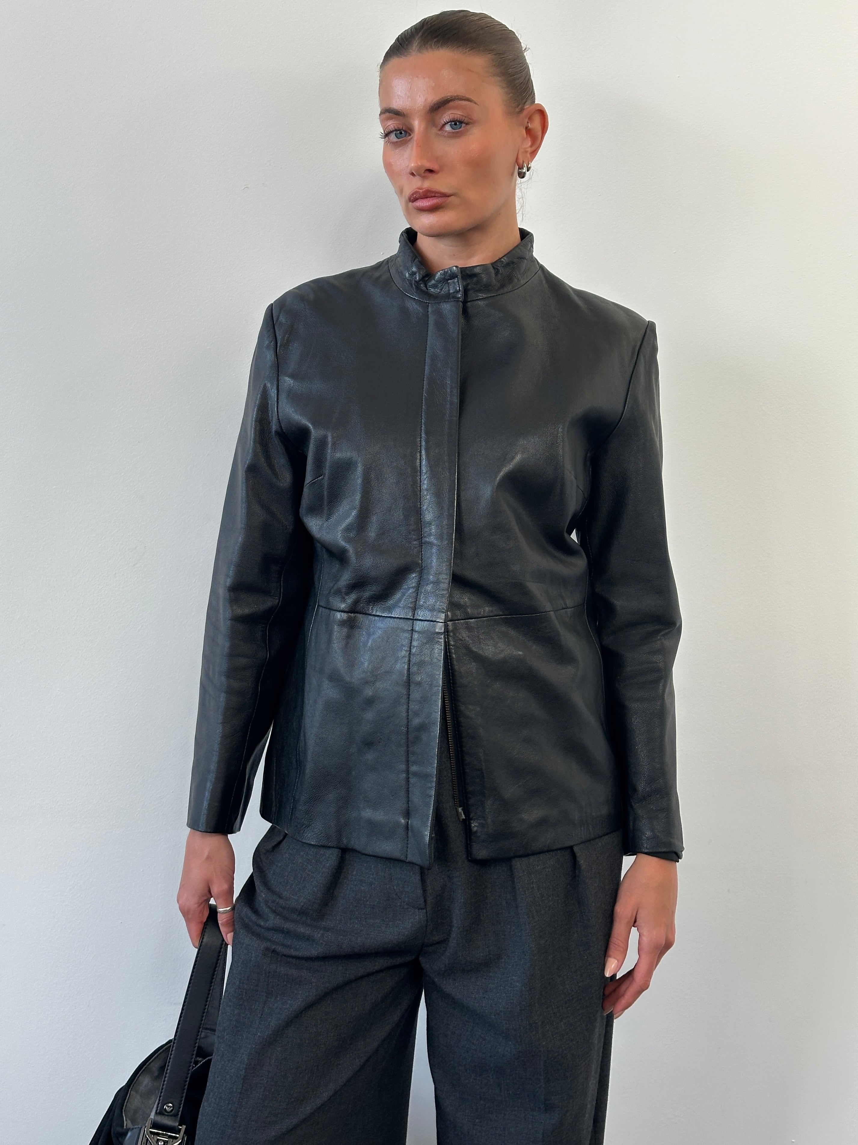 Vintage 1990s minimal round neck leather jacket in size M, featuring classic black leather and simple design.