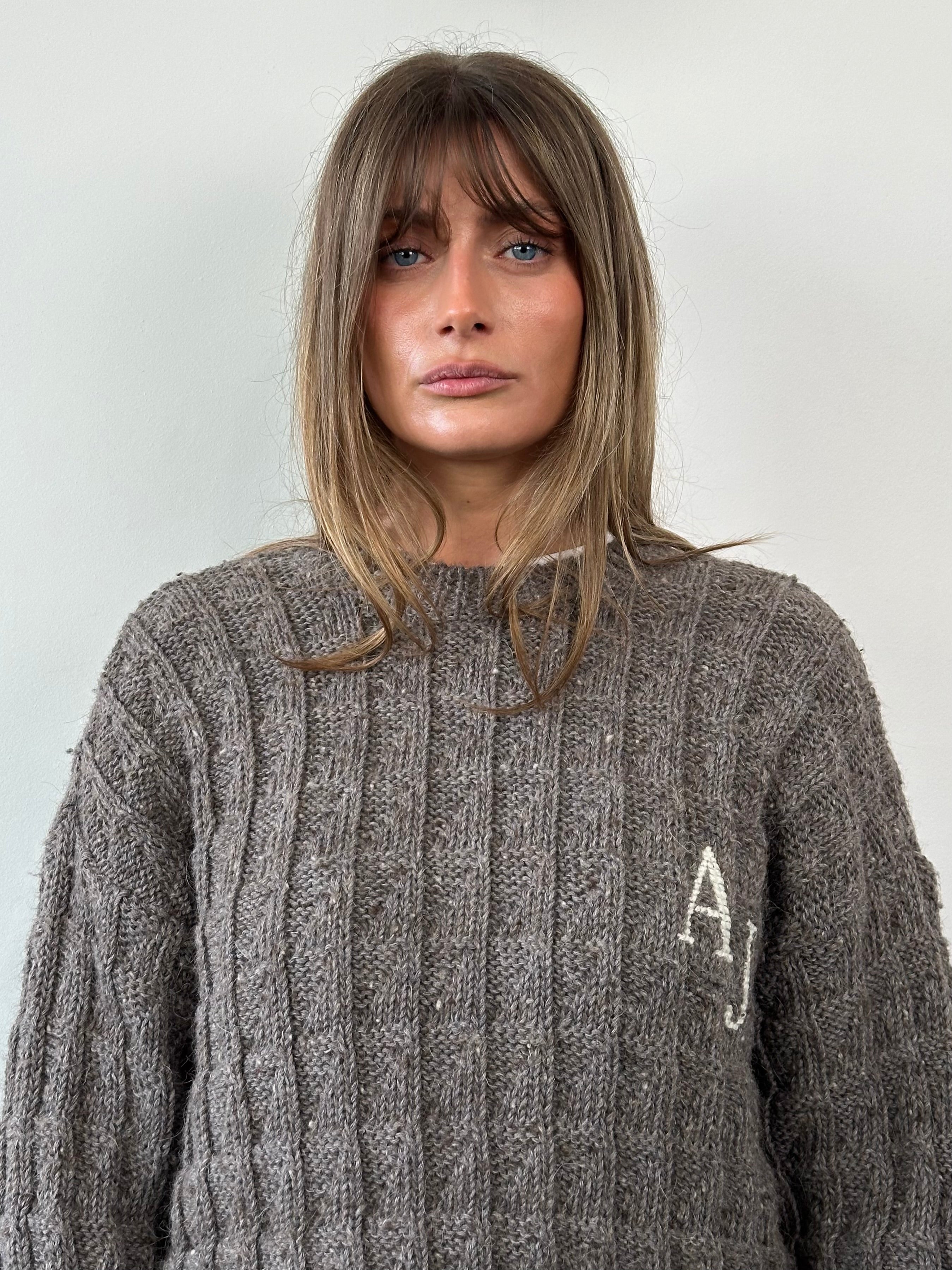 Armani Jeans wool alpaca knitted jumper with AJ logo in black, featuring a ribbed collar and cuffs, worn by a model.