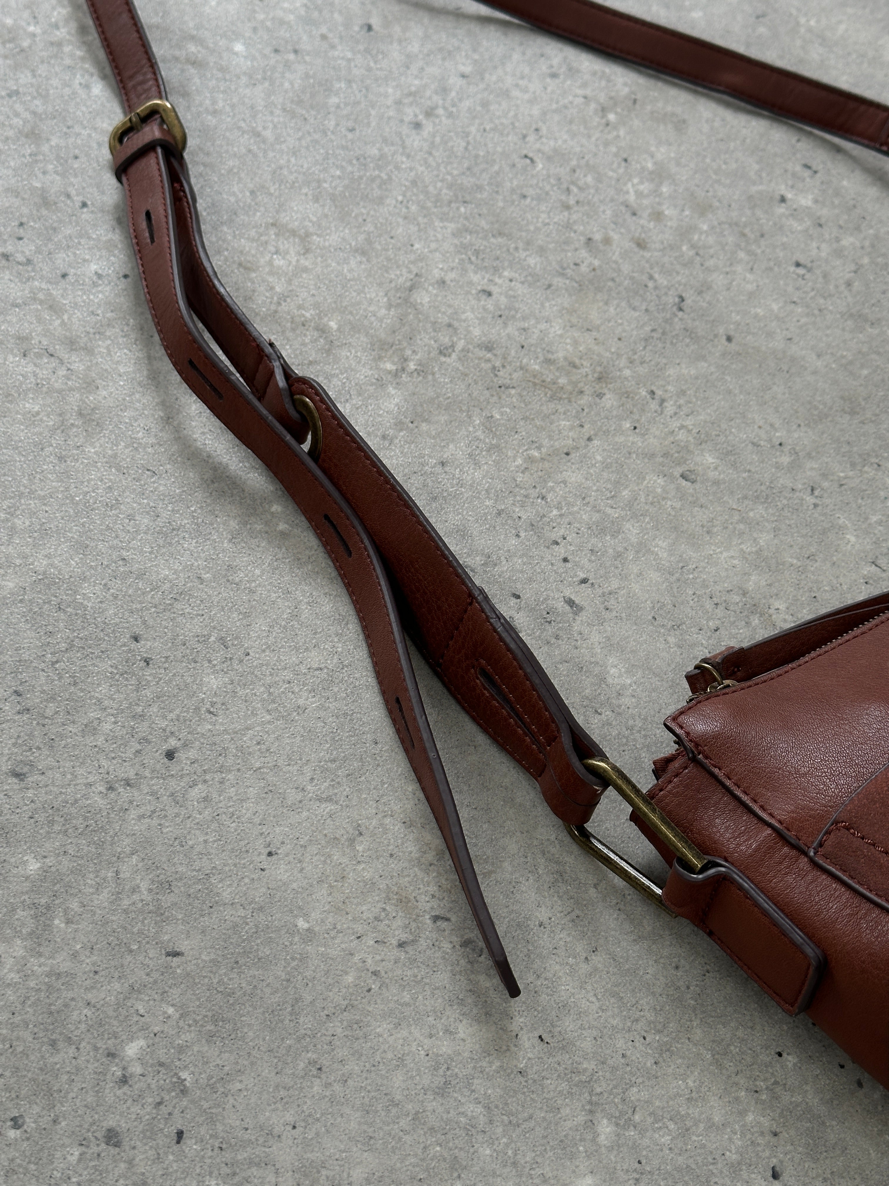 Vintage faux leather crescent crossbody bag with adjustable strap and antique finish, stylish and compact for everyday use.
