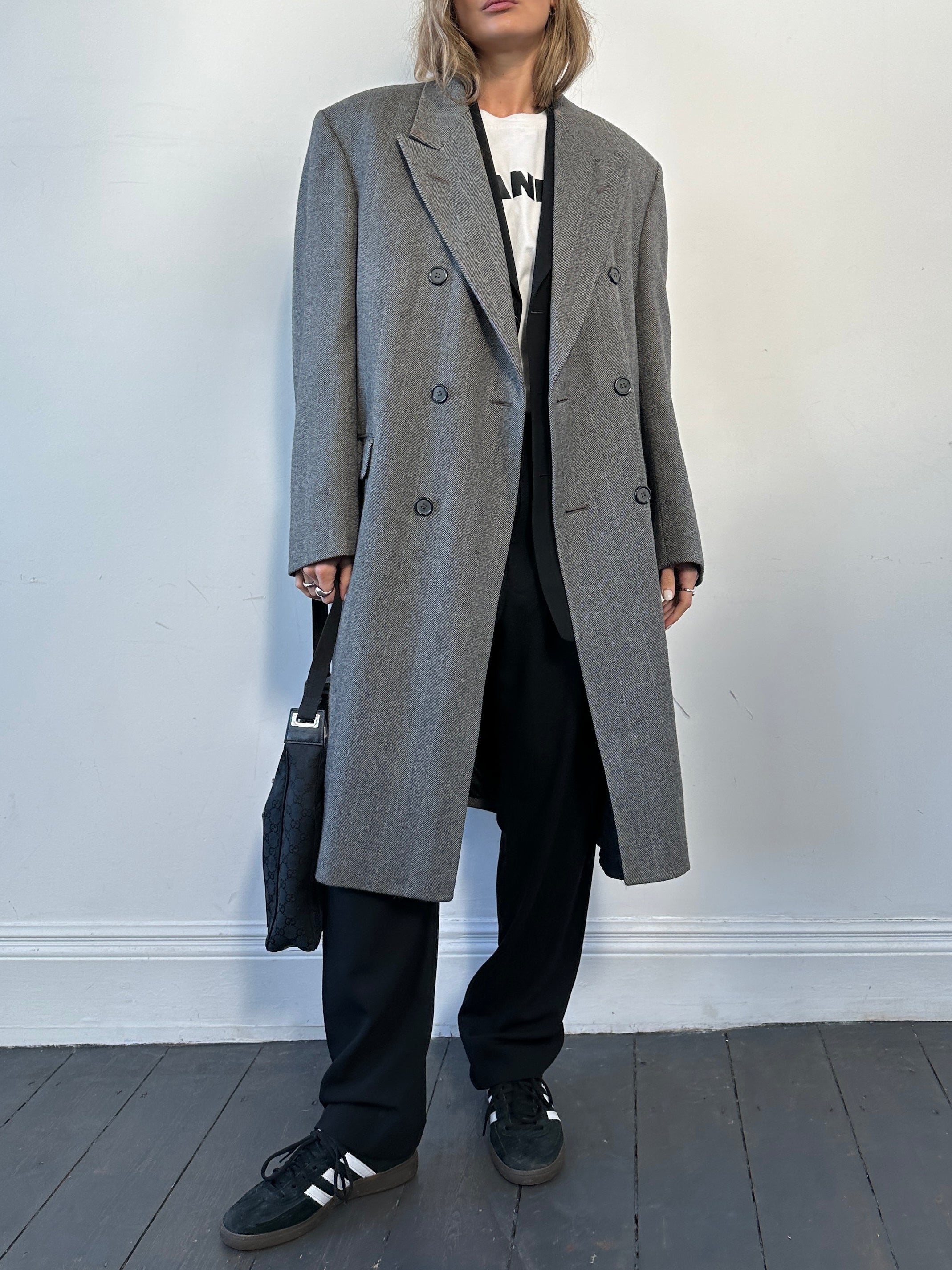 Vintage British vintage pure wool double-breasted herringbone coat in size L/XL, showcasing classic tailored design and textured fabric.