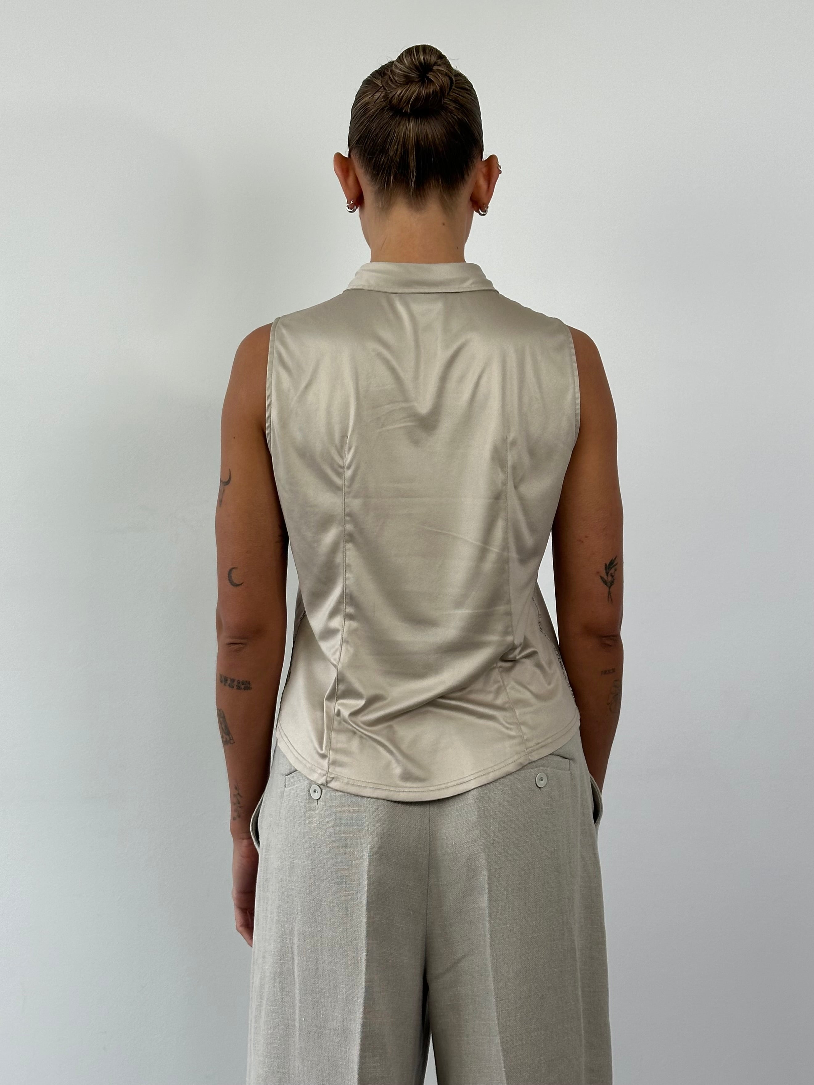 Fendi sleeveless satin logo shirt in size M/L displayed on a hanger, featuring smooth fabric and bold brand logo design.
