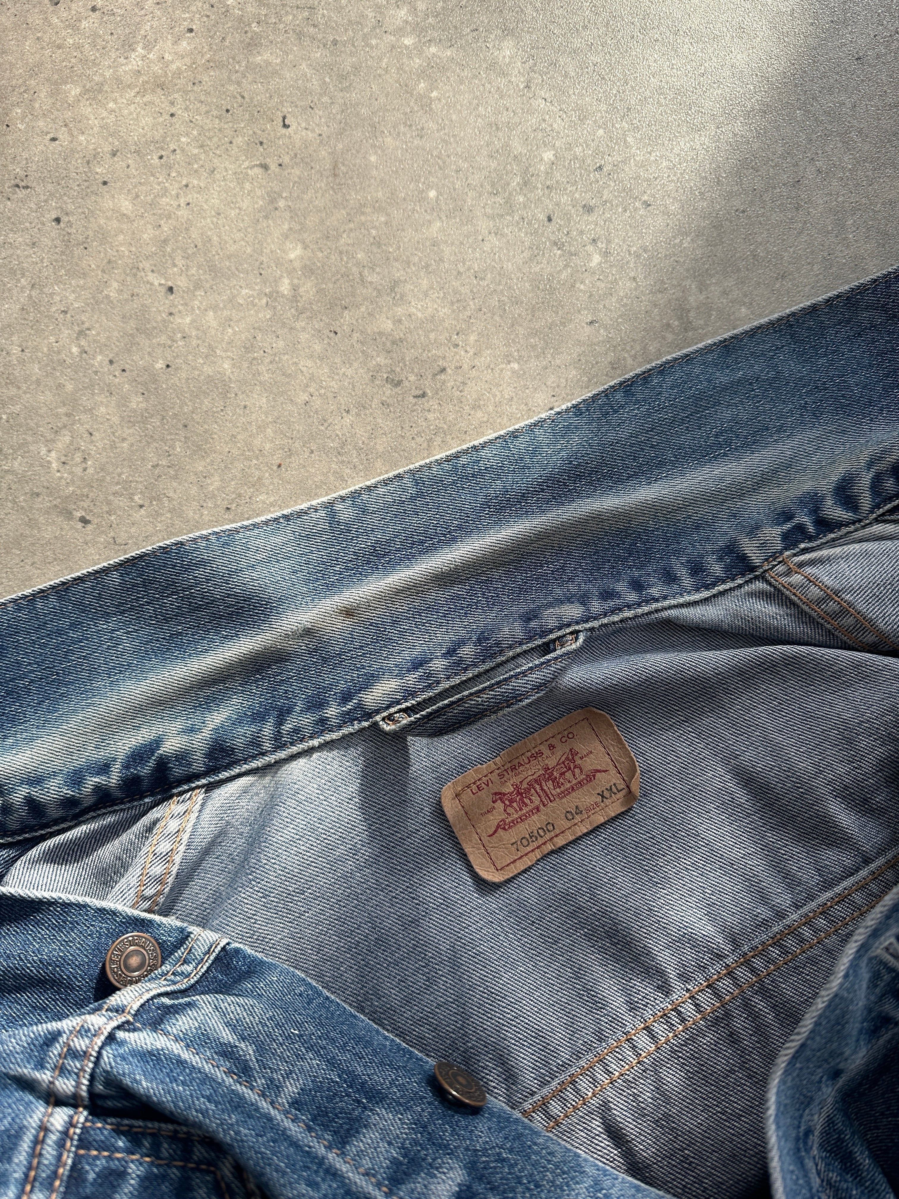 Levi’s faded denim jacket in size L, showcasing classic distressed denim with a button-up front and collar detail.