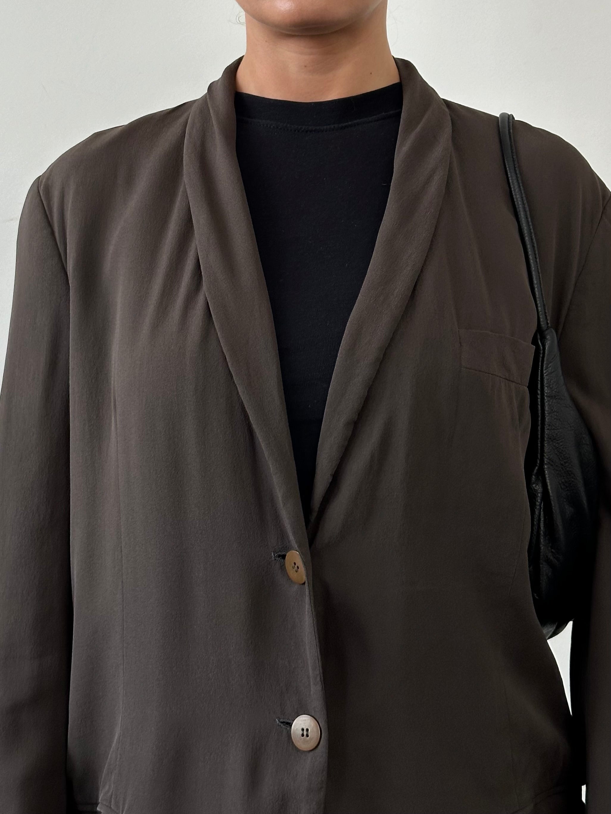 Giorgio Armani Black Label silk blazer in black, tailored fit, with lapel collar and button closure, displayed on a hanger.