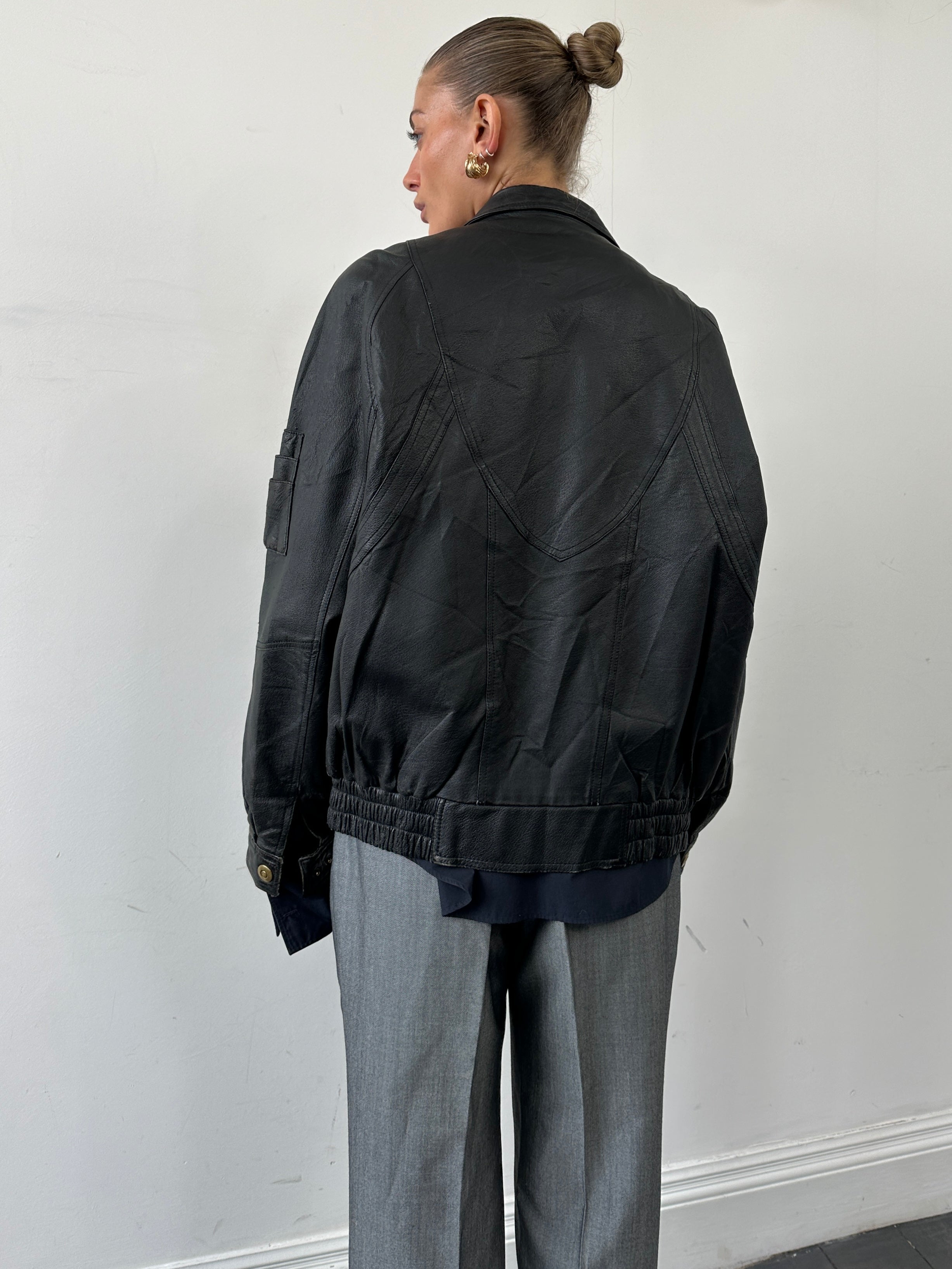 Vintage leather bomber jacket in large/x-large size, showcasing classic design with a smooth leather finish and ribbed collar.
