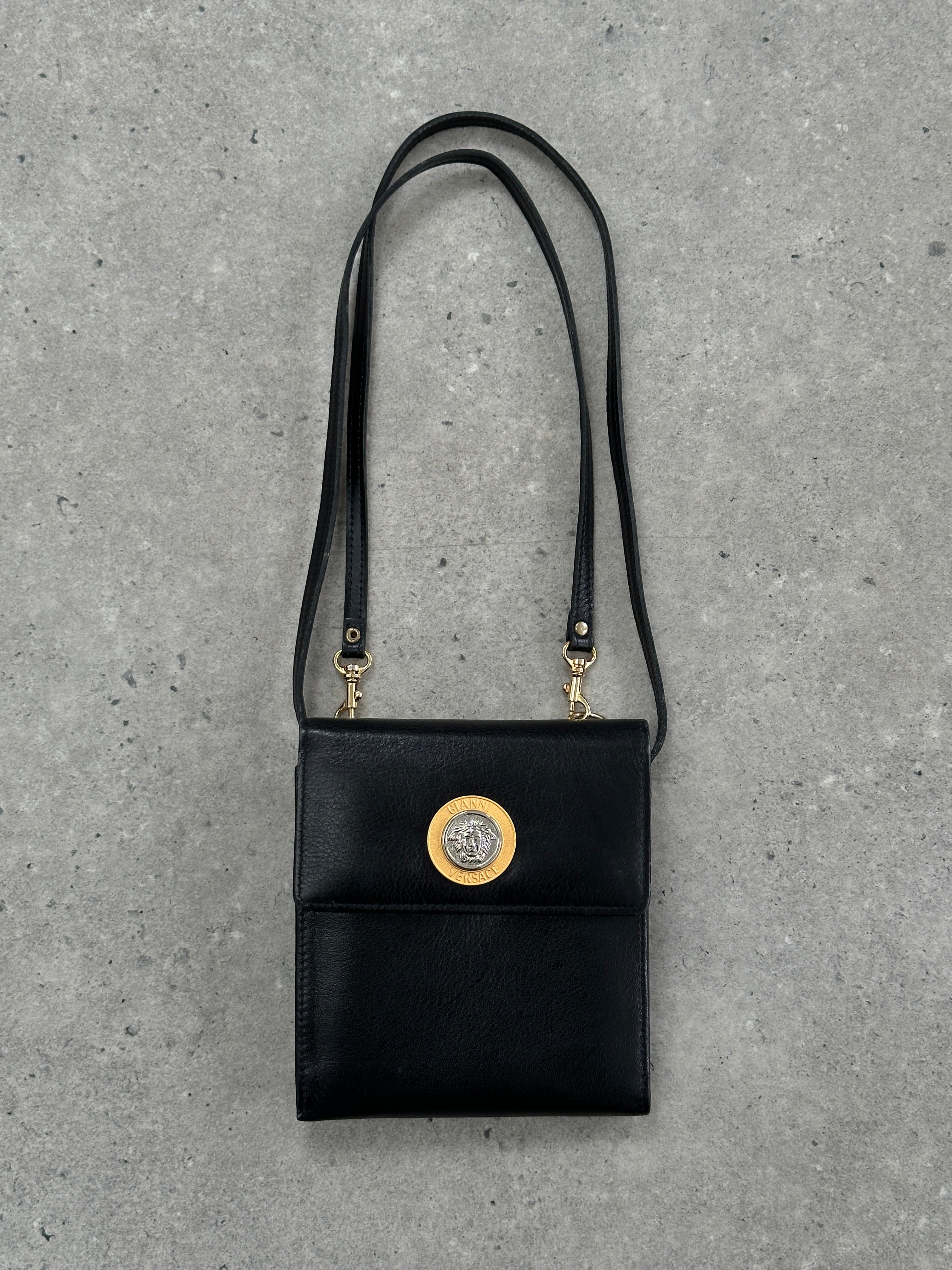 Gianni Versace 1990s Medusa leather crossbody bag featuring bold Medusa logo and sleek black leather strap.