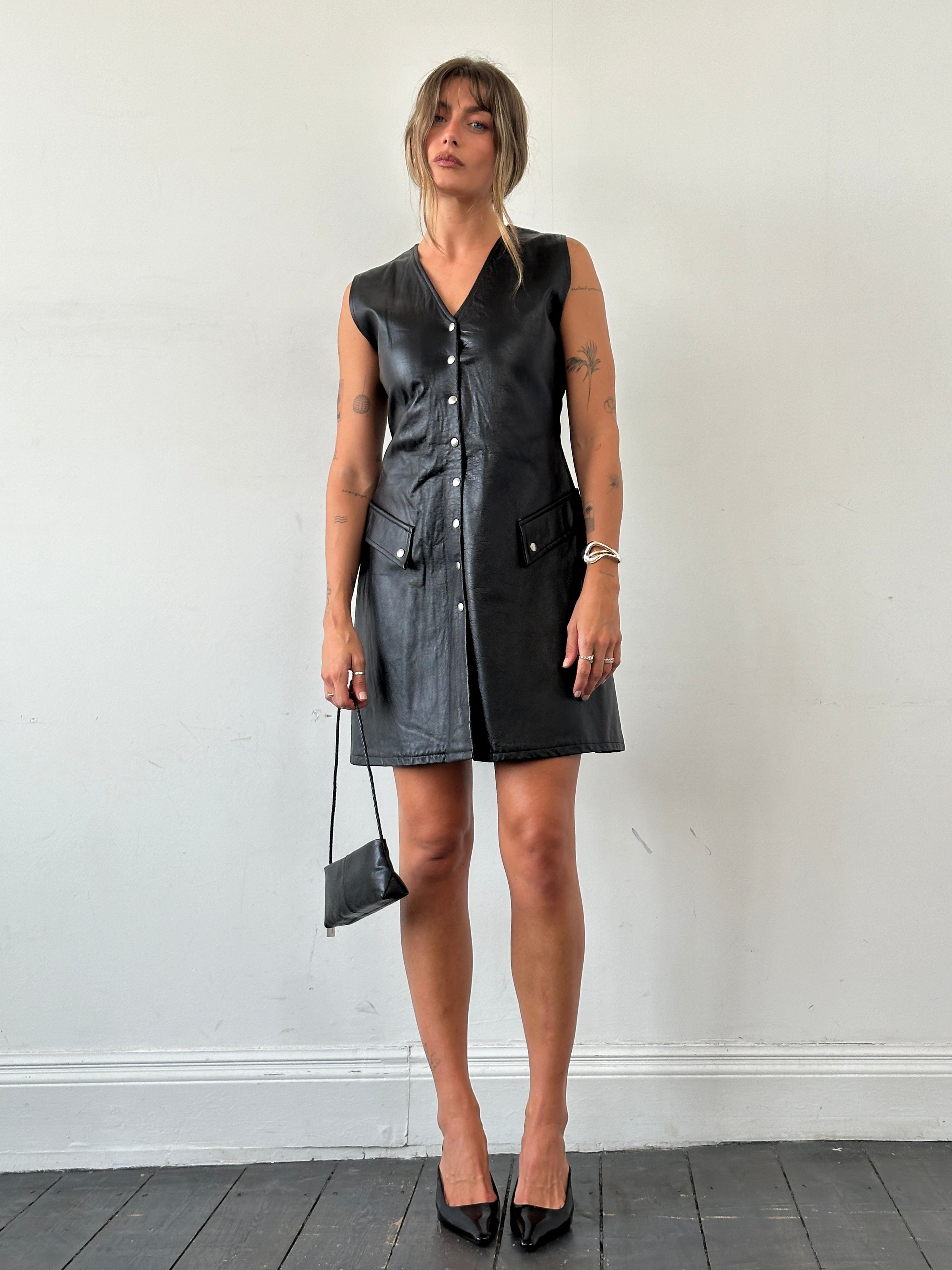 Vintage fitted leather button-up dress in size S, showcasing classic style and sleek design with detailed stitching and collar.