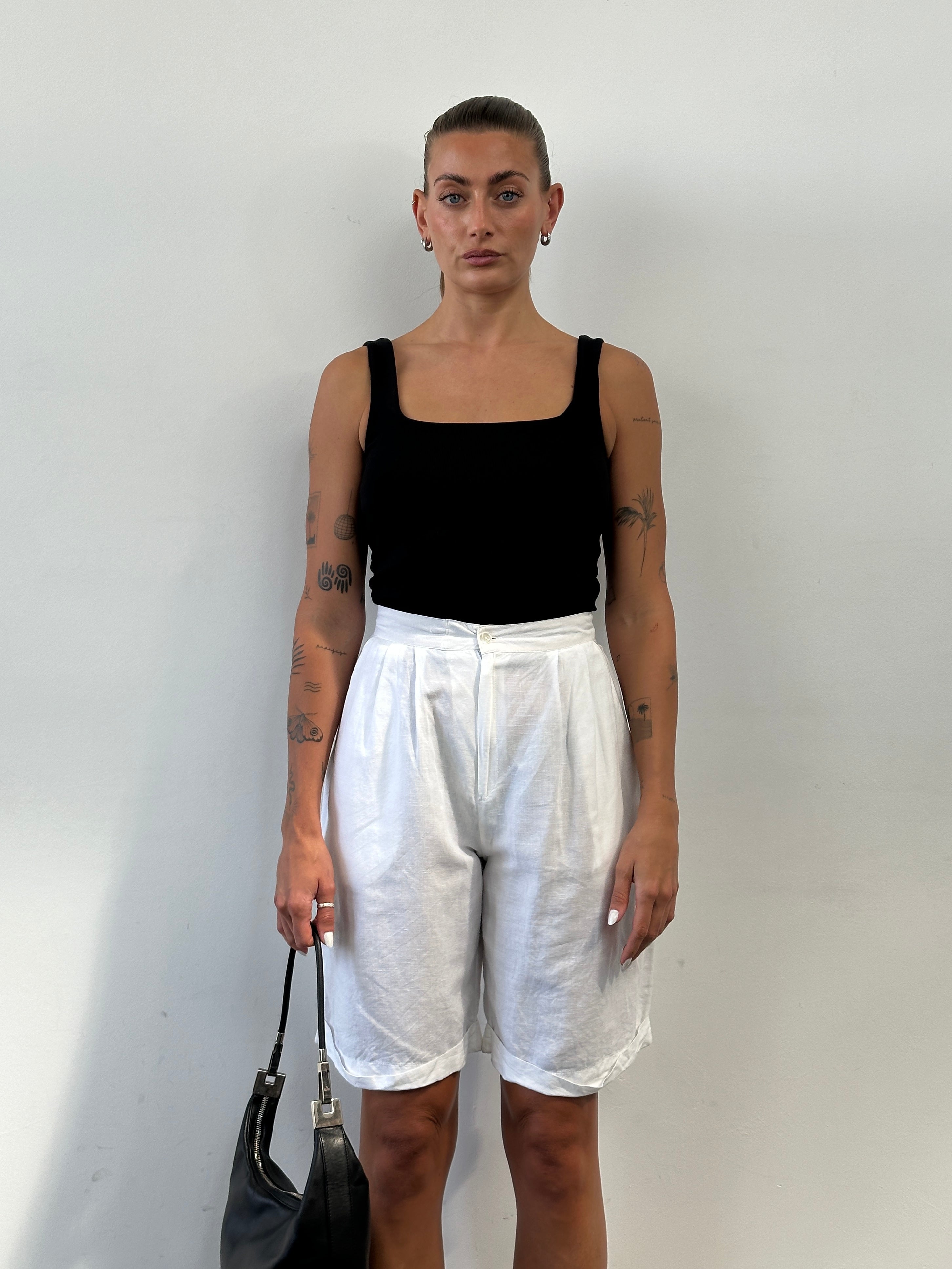 Vintage linen pleated high-waisted wide Bermuda shorts in a light fabric with a tailored fit and classic style.