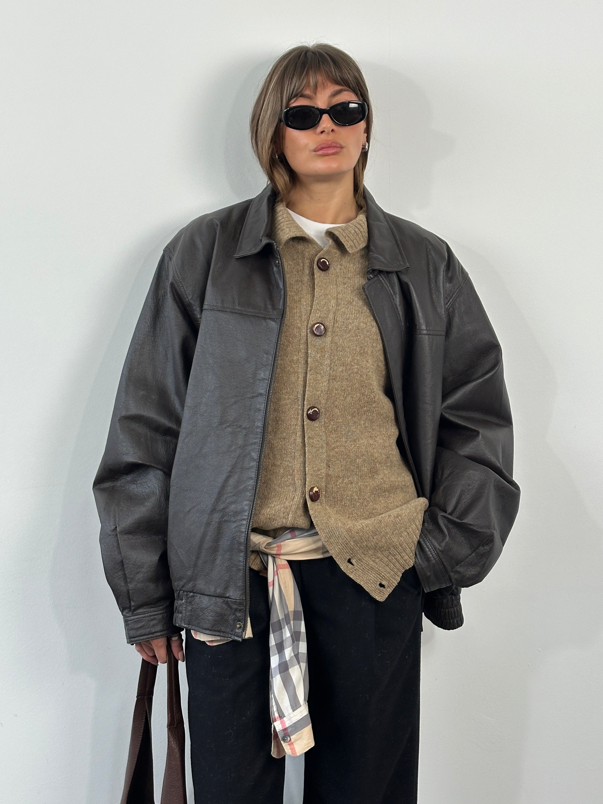 Vintage 1990s leather bomber jacket with concealed placket, in XL/XXL size, featuring classic design and brown leather exterior.