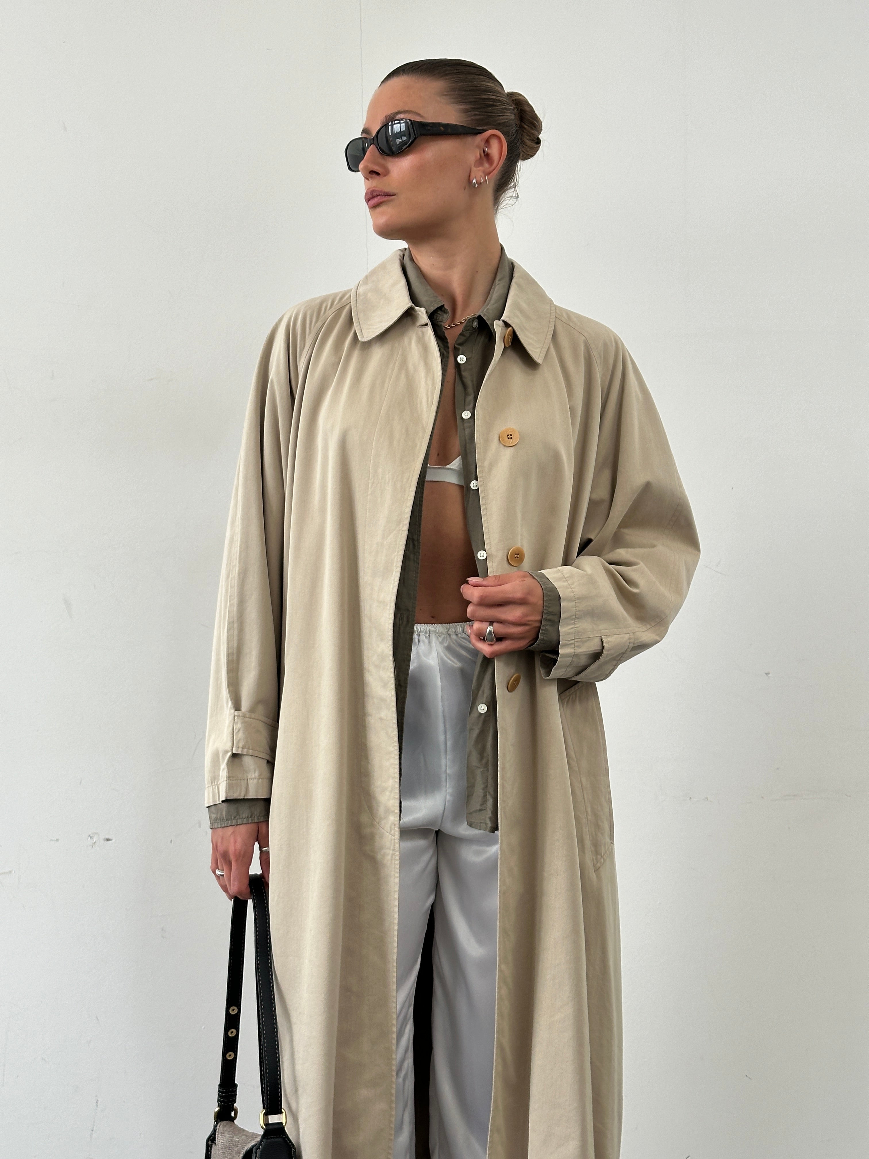 Mani cotton cupro belted trench coat in size L/XL displayed on a hanger, showcasing its classic beige color and stylish design.