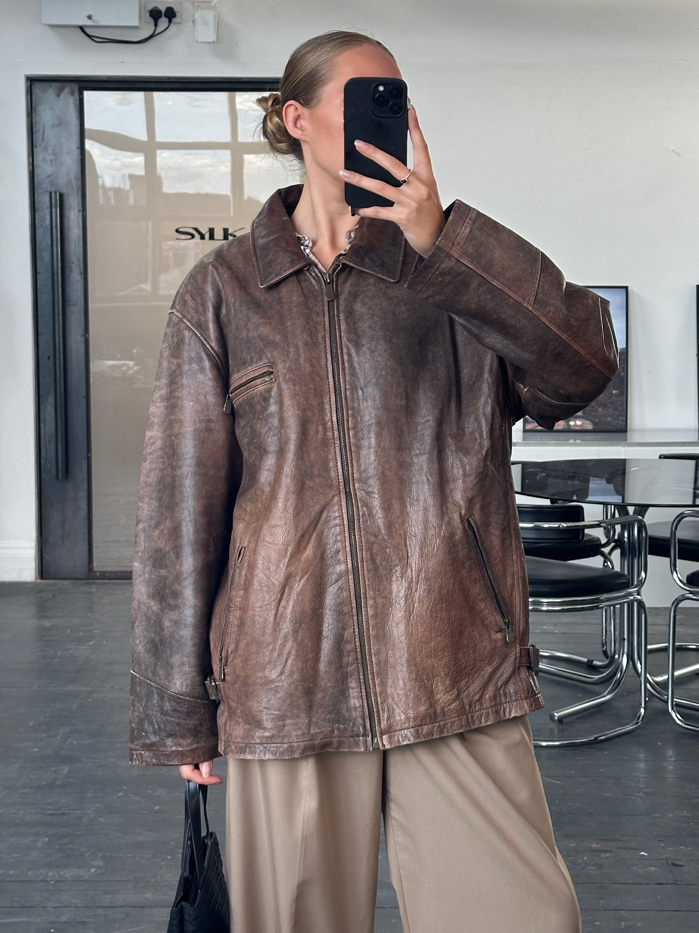 Vintage 1990s aged leather jacket in XL size, featuring distressed brown leather and classic design with vintage details.