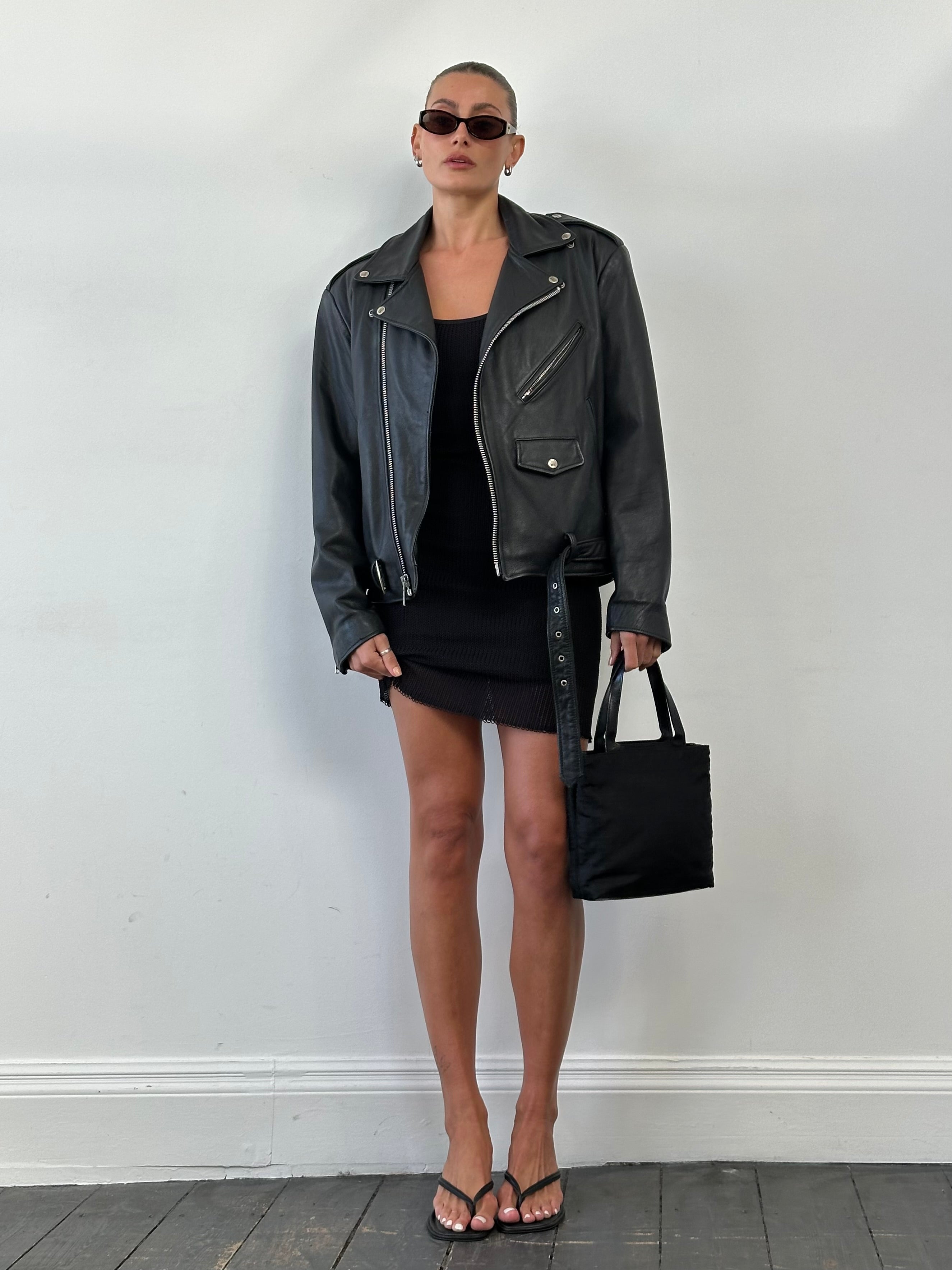 Vintage leather biker jacket in size M/L with classic styling, featuring rugged leather texture and metal hardware details.