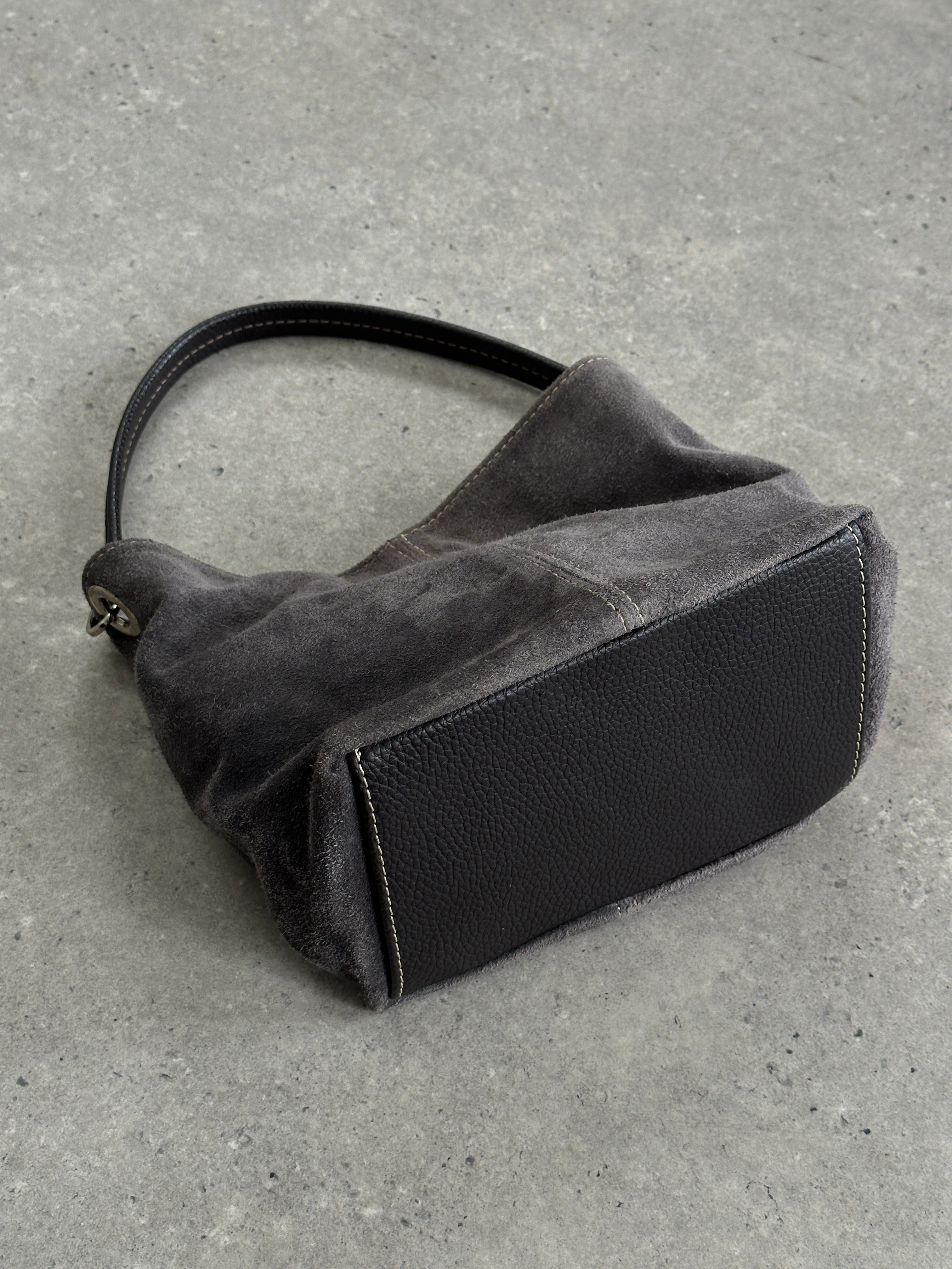 Vintage suede leather shoulder bag with adjustable strap, featuring a classic design and rustic finish.