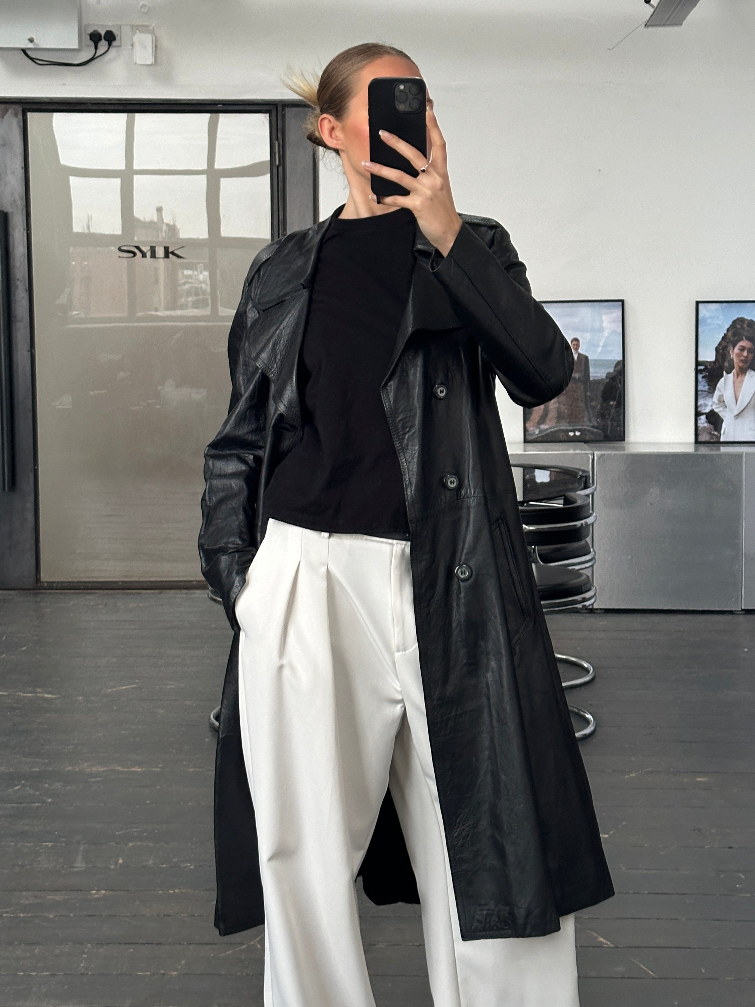 Vintage leather double-breasted trench coat from the 1990s, tailored fit, classic style, shown on a hanger.