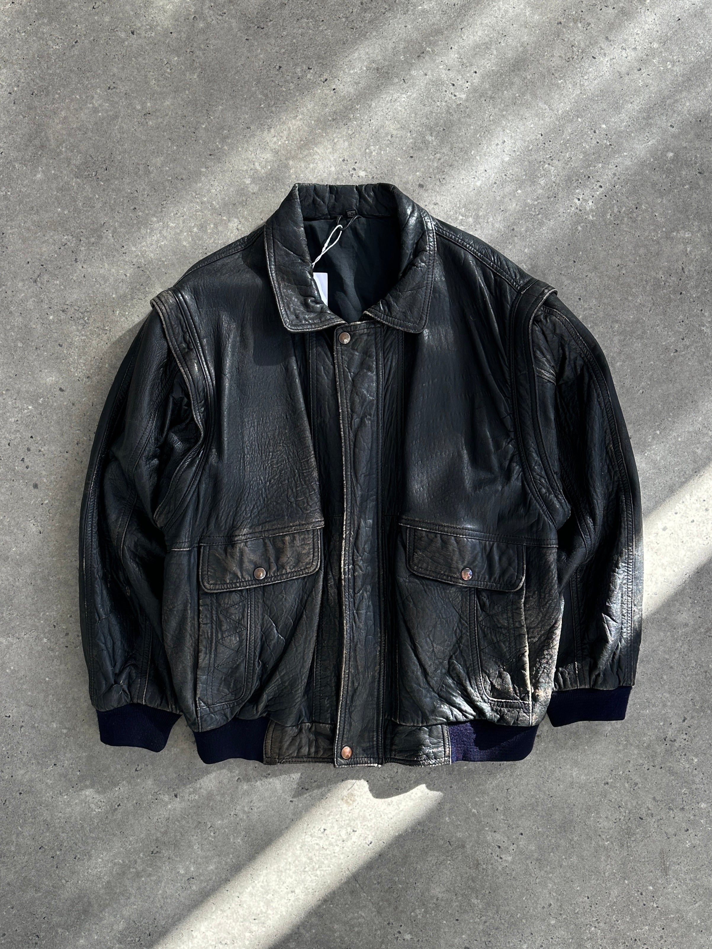 Vintage distressed leather bomber gilet jacket in size M/L, showing rugged texture and classic design details.