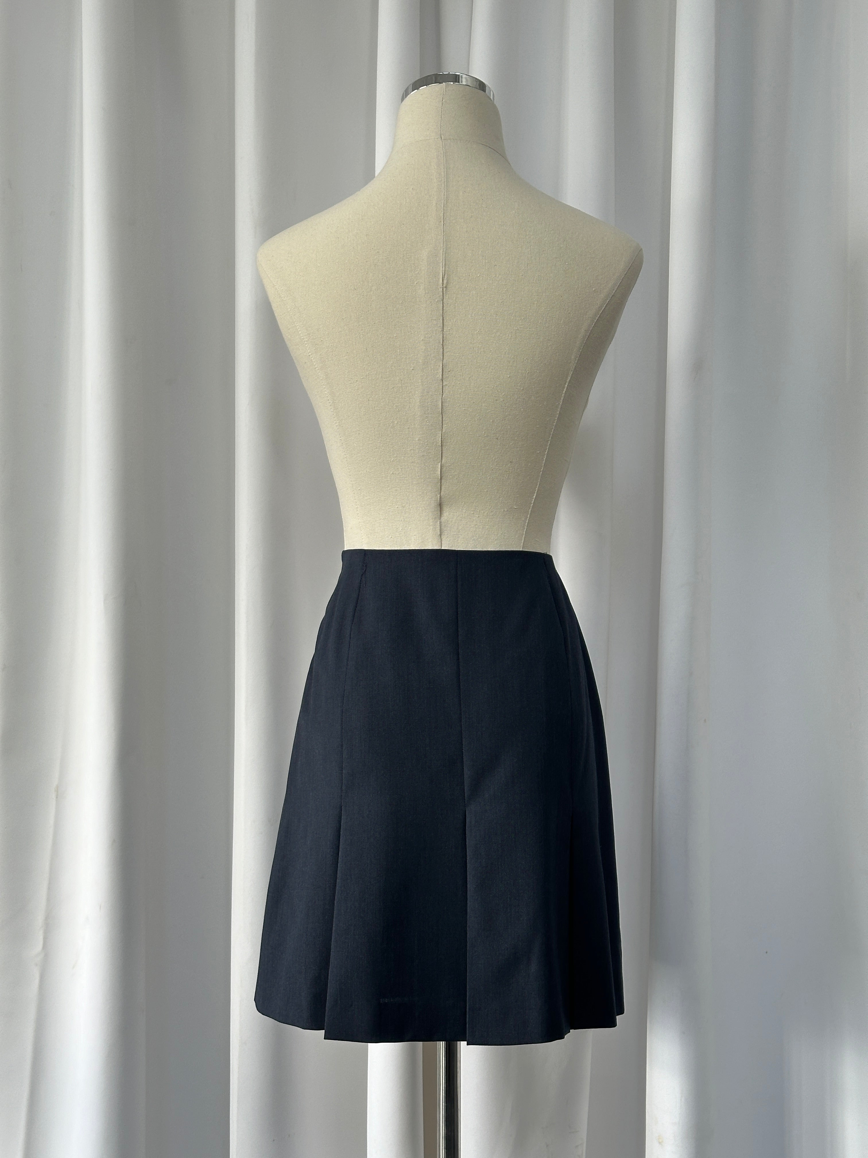 Vintage Italian 1990s pure Merino wool pleated mini skirt, W24, with classic design and textured fabric.