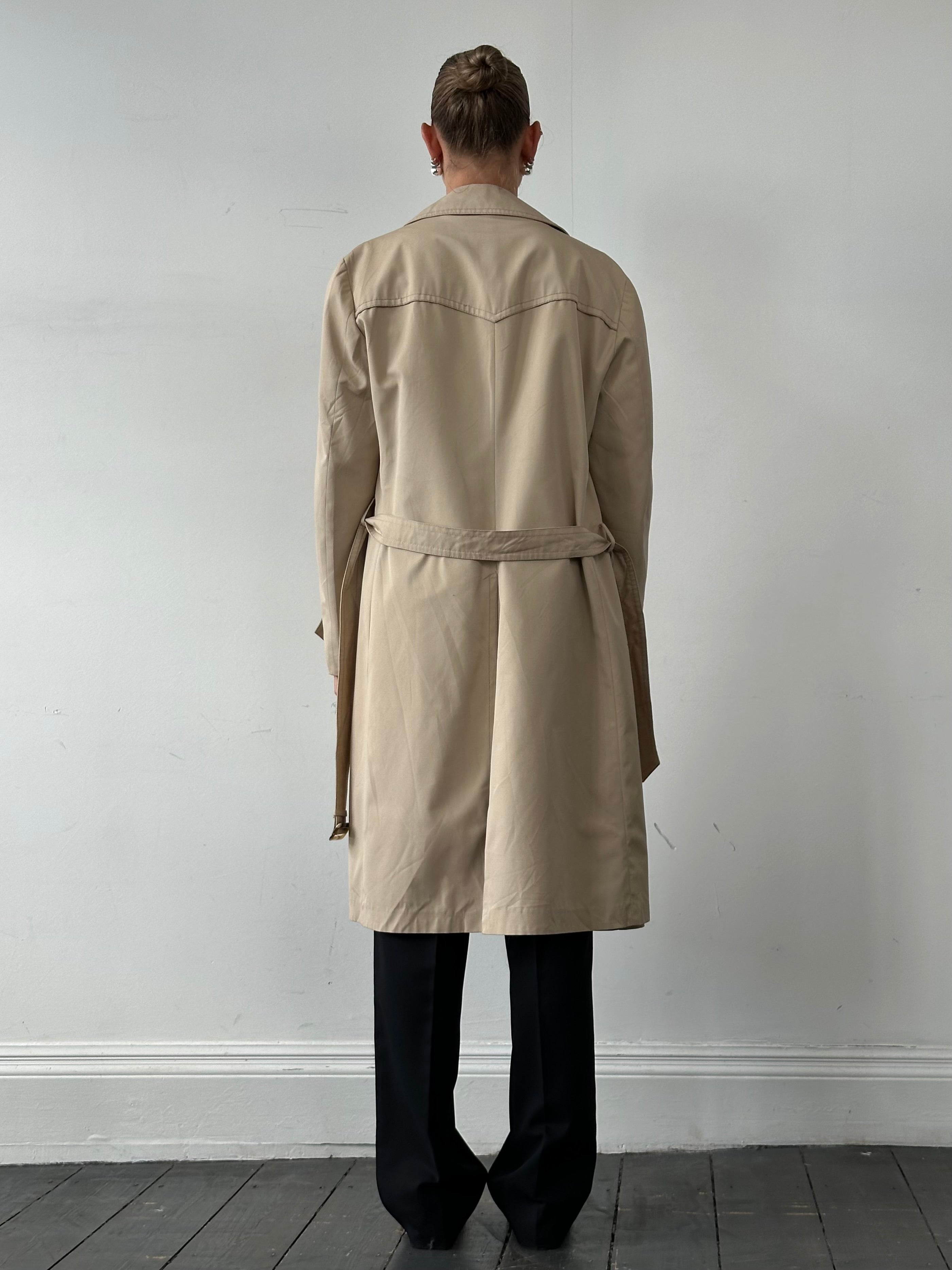 Vintage double-breasted belted trench coat in classic style, shown on a hanger with details of fabric and design.