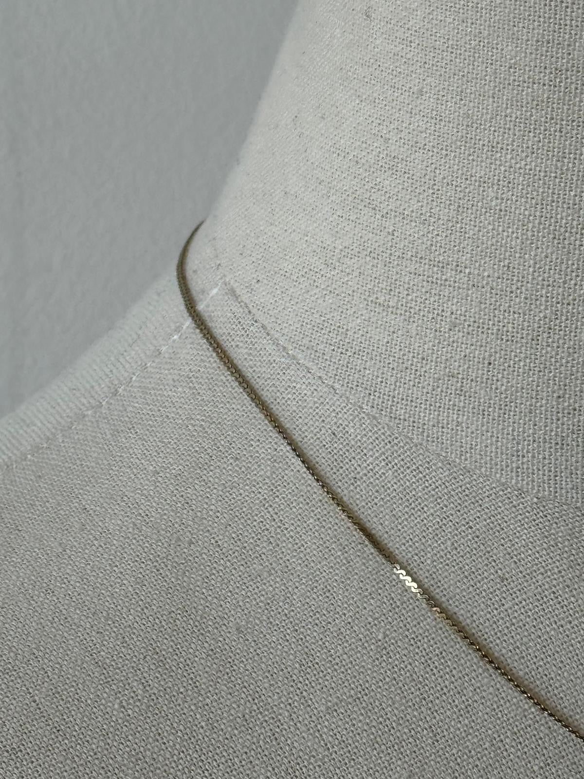 Pierre Cardin 1990s gold-plated fine necklace with delicate chain and elegant design, displayed on a neutral background.