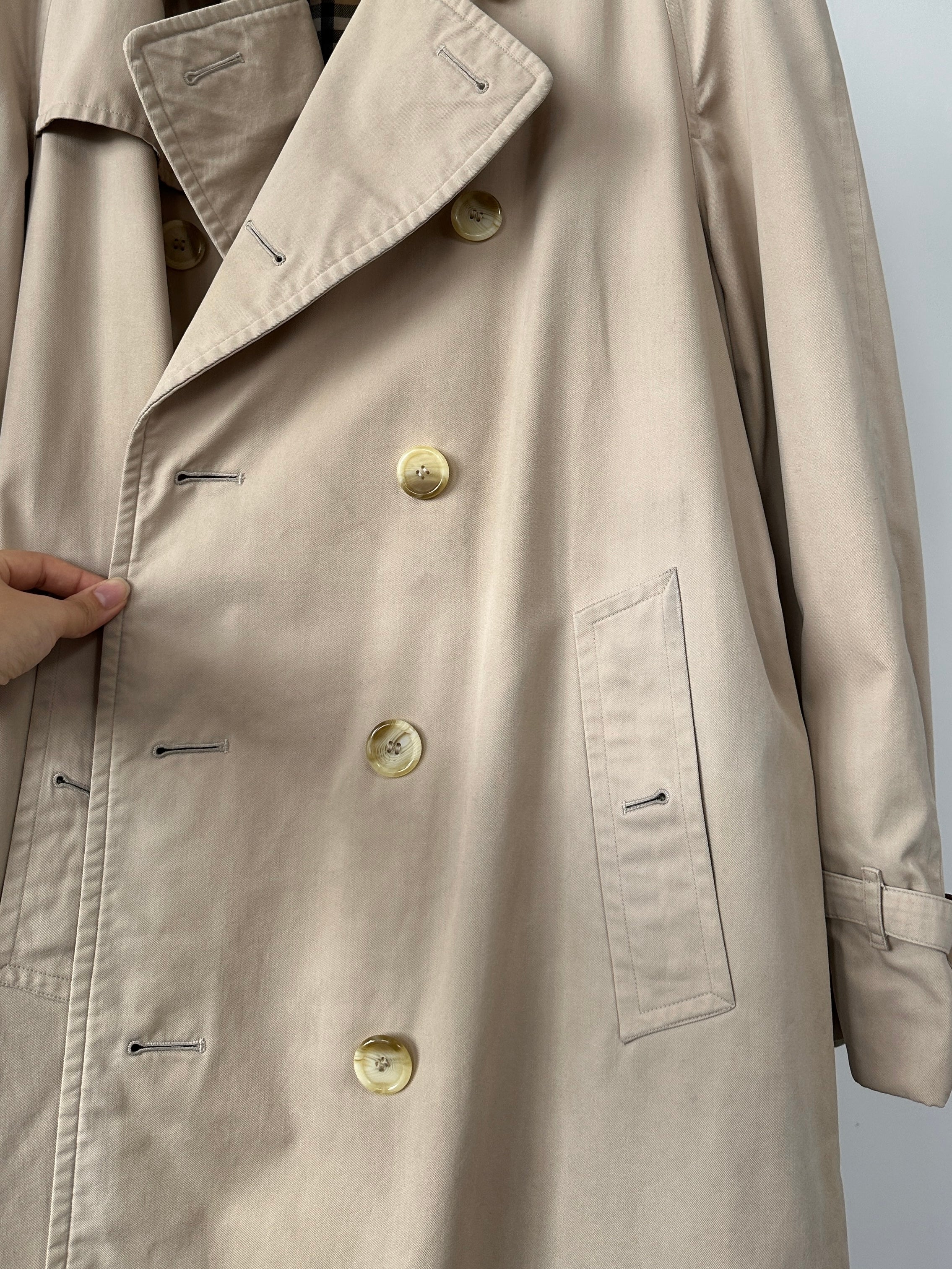 Burberry double-breasted trench coat in XL size, classic beige color, showing button details and belt at waist.