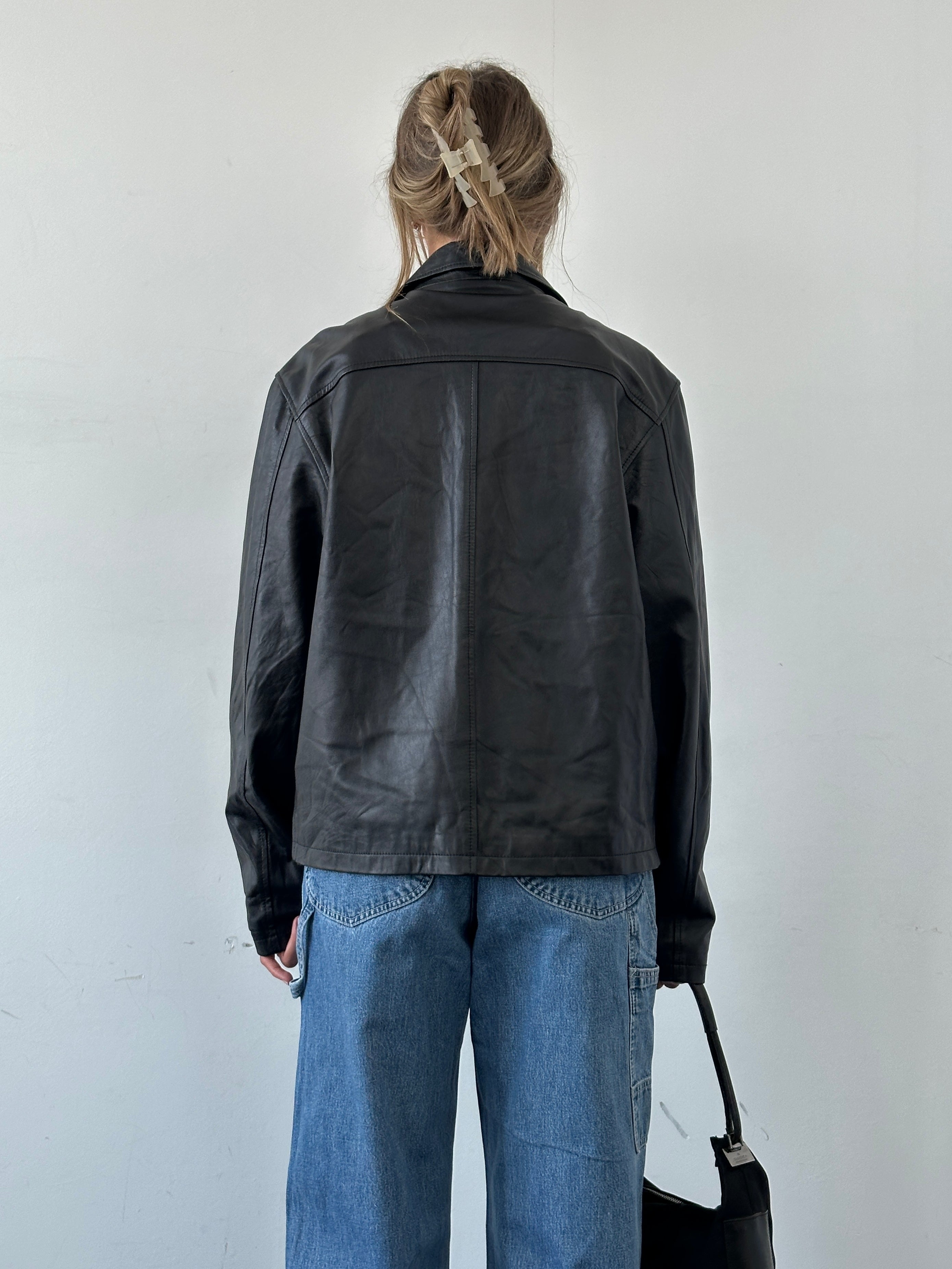 Vintage Italian leather jacket with minimal design, zip-up front, in size large, showcasing classic vintage style and craftsmanship.