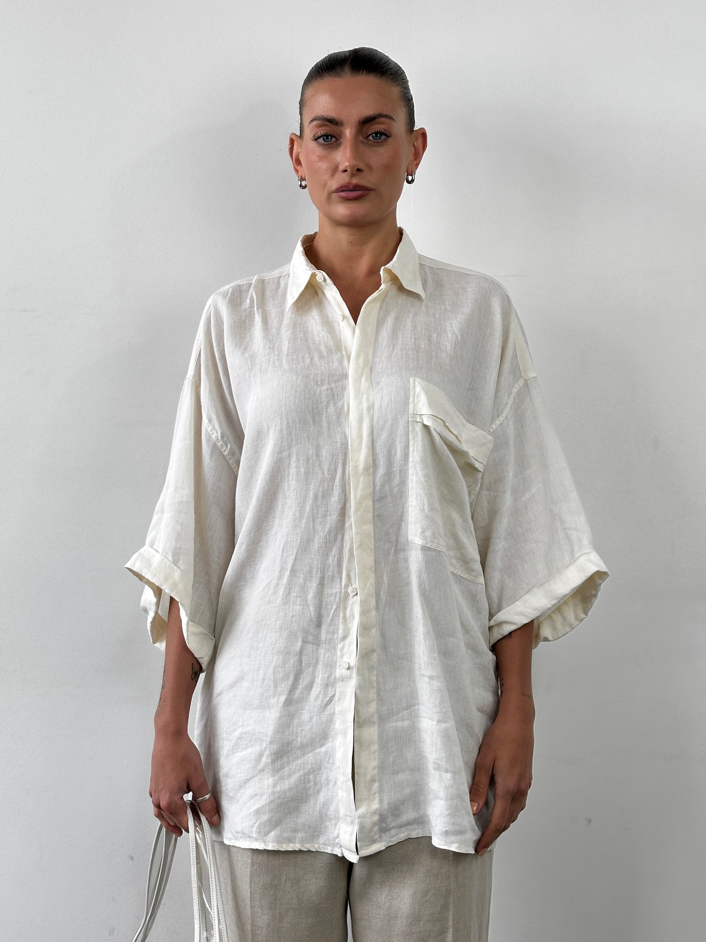 Versace 90s oversized pure linen shirt in XL displayed on a hanger, showcasing classic design and luxurious fabric.