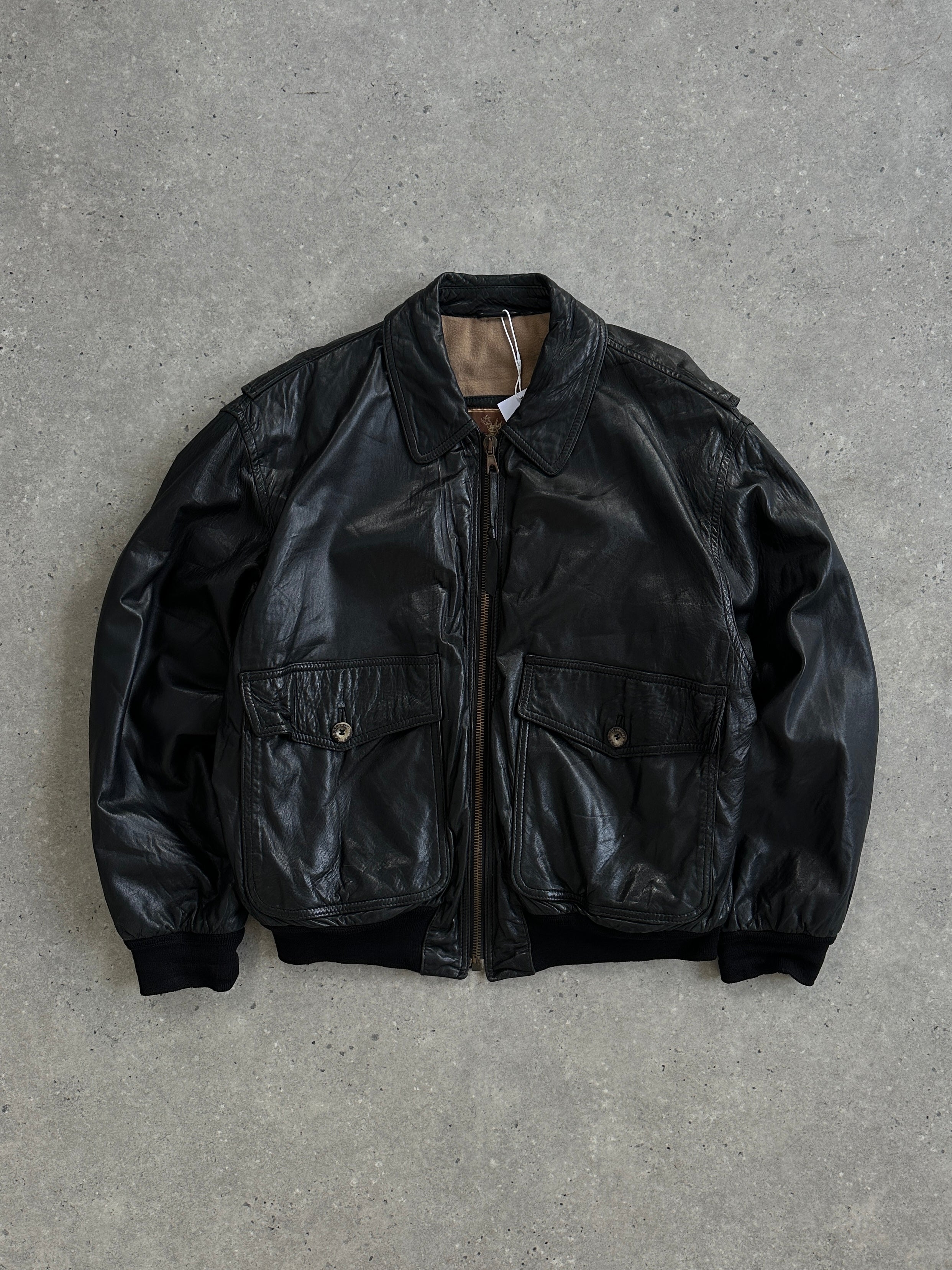 Vintage leather bomber jacket, size large, featuring classic collar and zip closure, styled with rugged leather texture.