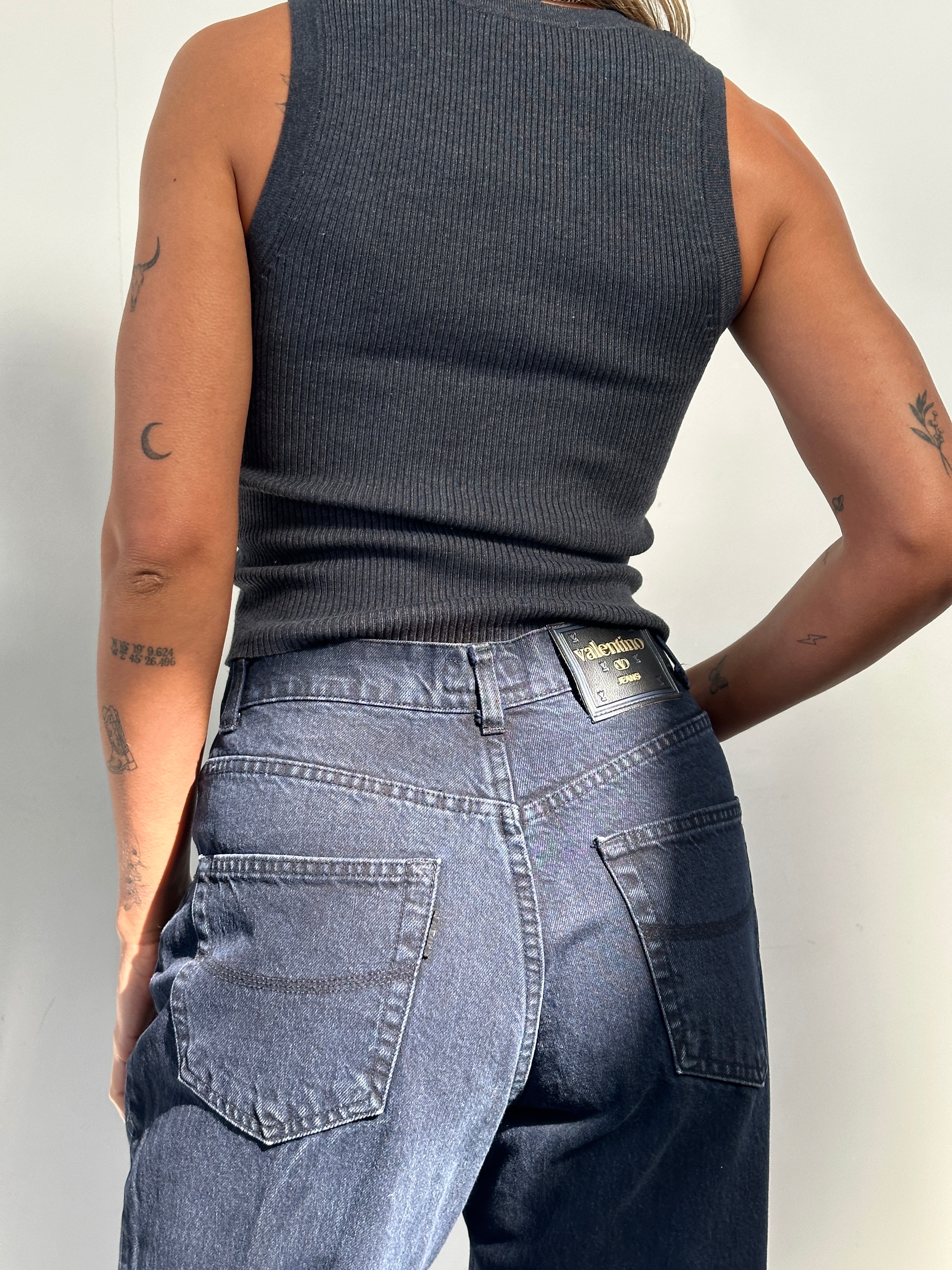 Valentino tapered high-waisted denim jeans in W28, featuring classic blue wash and modern cut, displayed on a hanger.