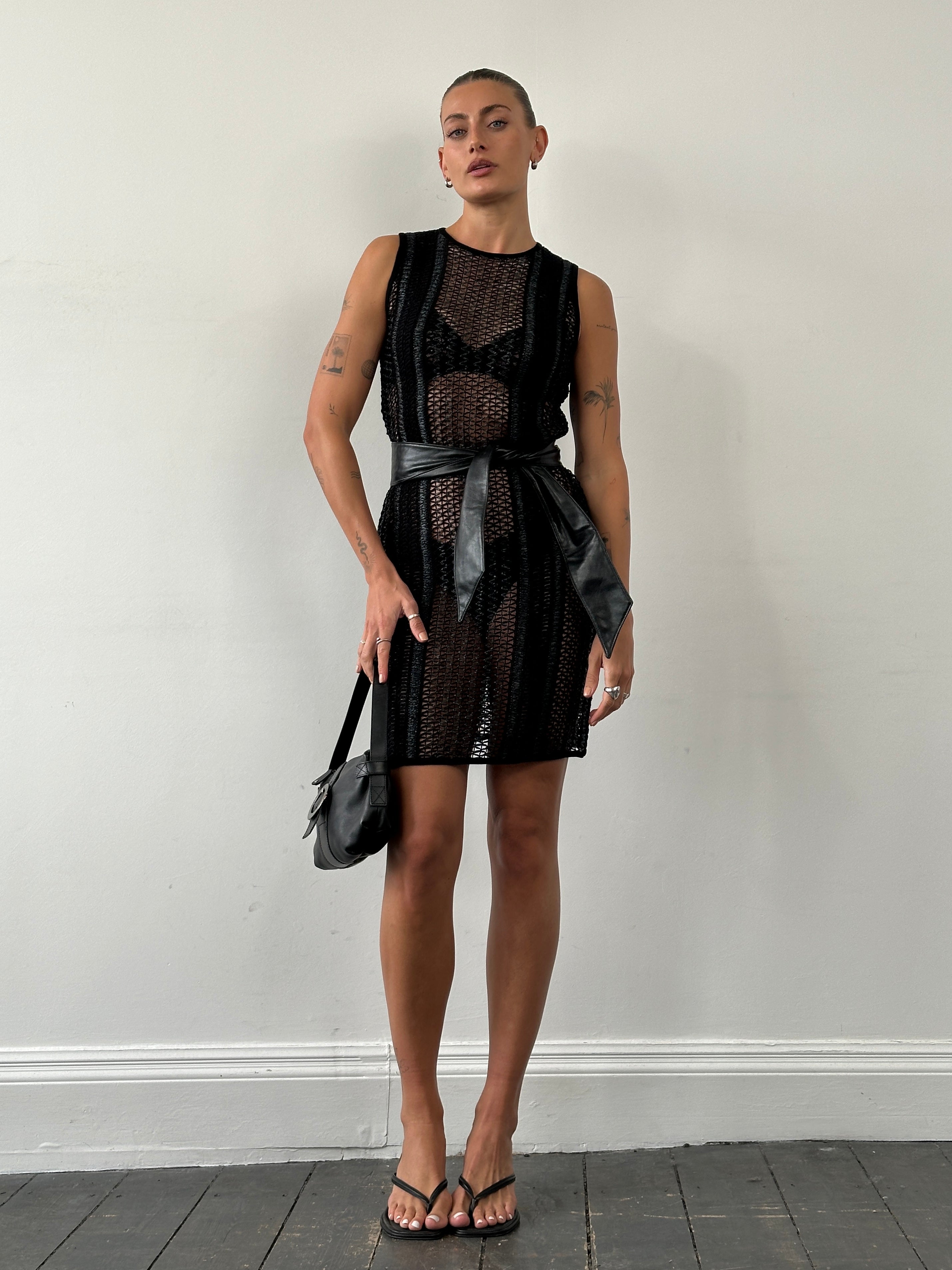 Vintage rattan crochet mini dress in S/M displayed on a hanger, showcasing its intricate pattern and vintage boho style.