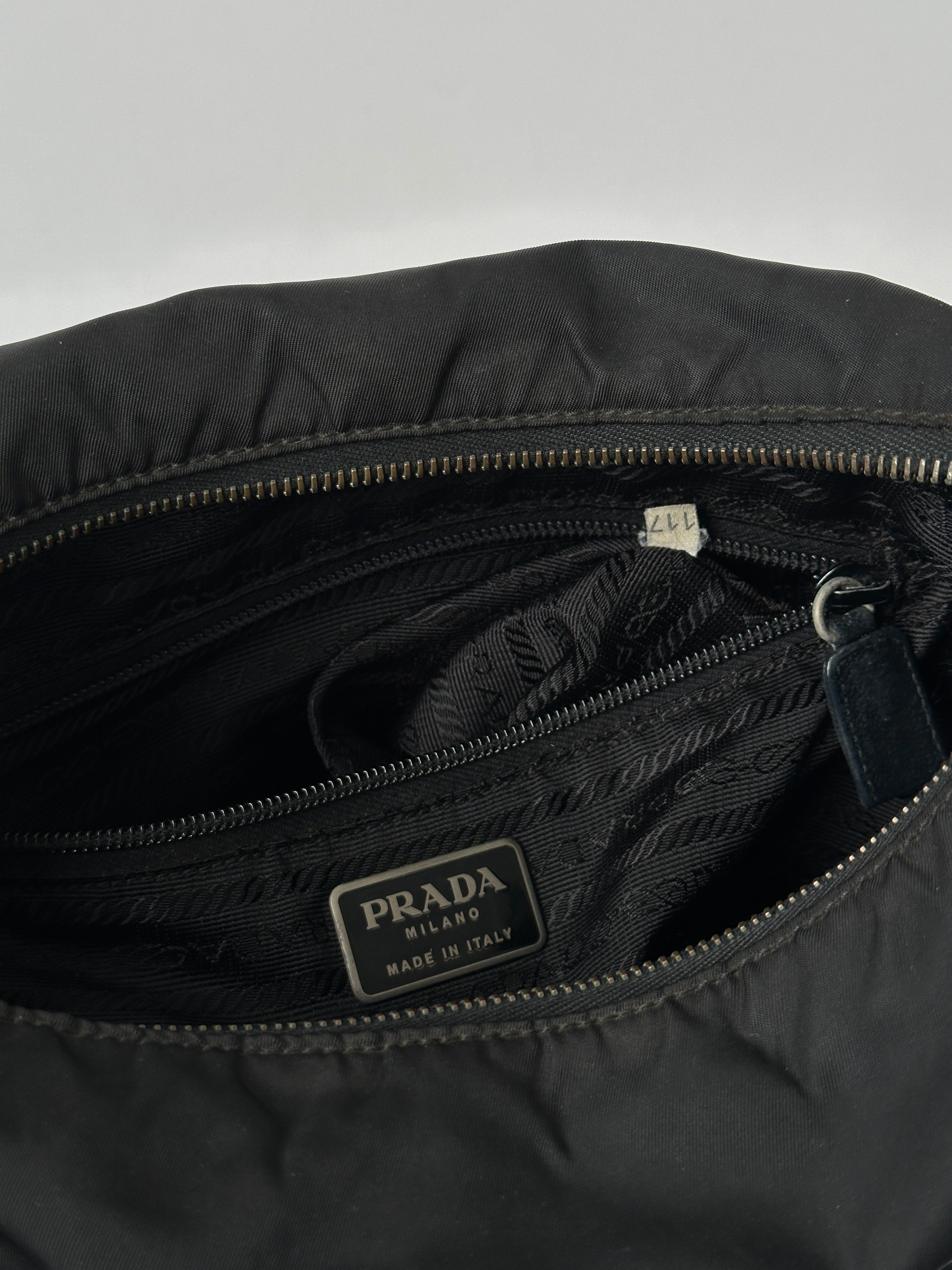 Prada nylon and leather crossbody bag with adjustable strap and sleek design, perfect for everyday use.