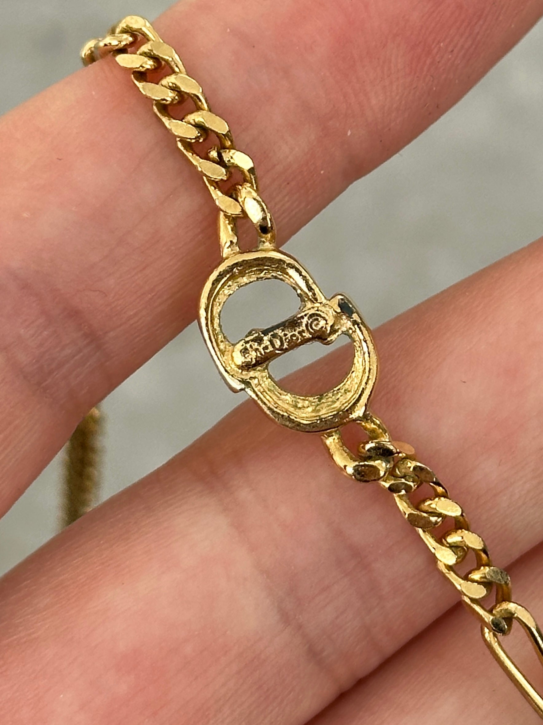 Christian Dior 18-inch gold plated logo pendant necklace featuring a sleek, elegant design with a prominent Dior logo charm.