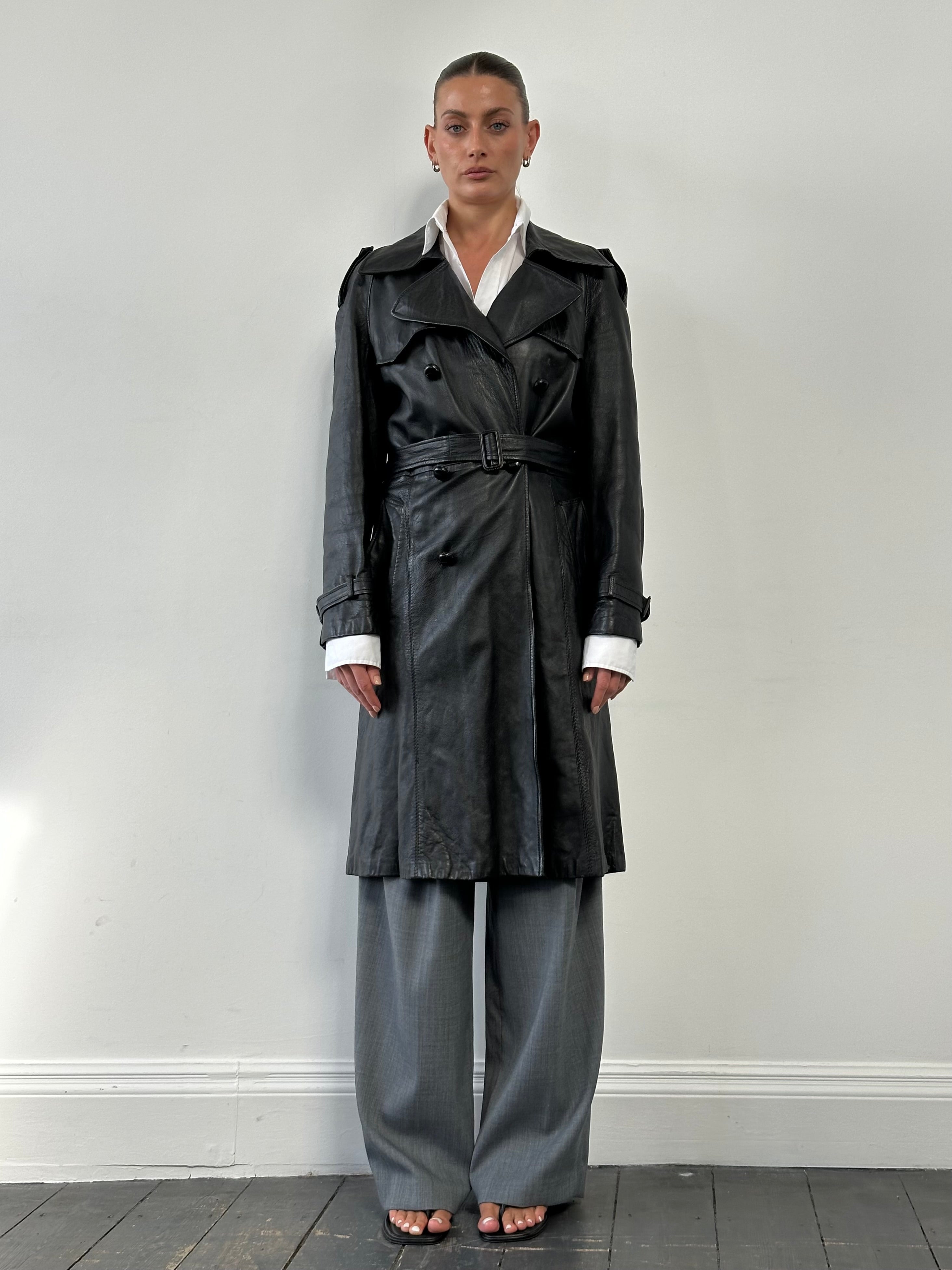 Vintage leather double-breasted belted trench coat, size M, featuring classic design, lapels, and stylish button details.