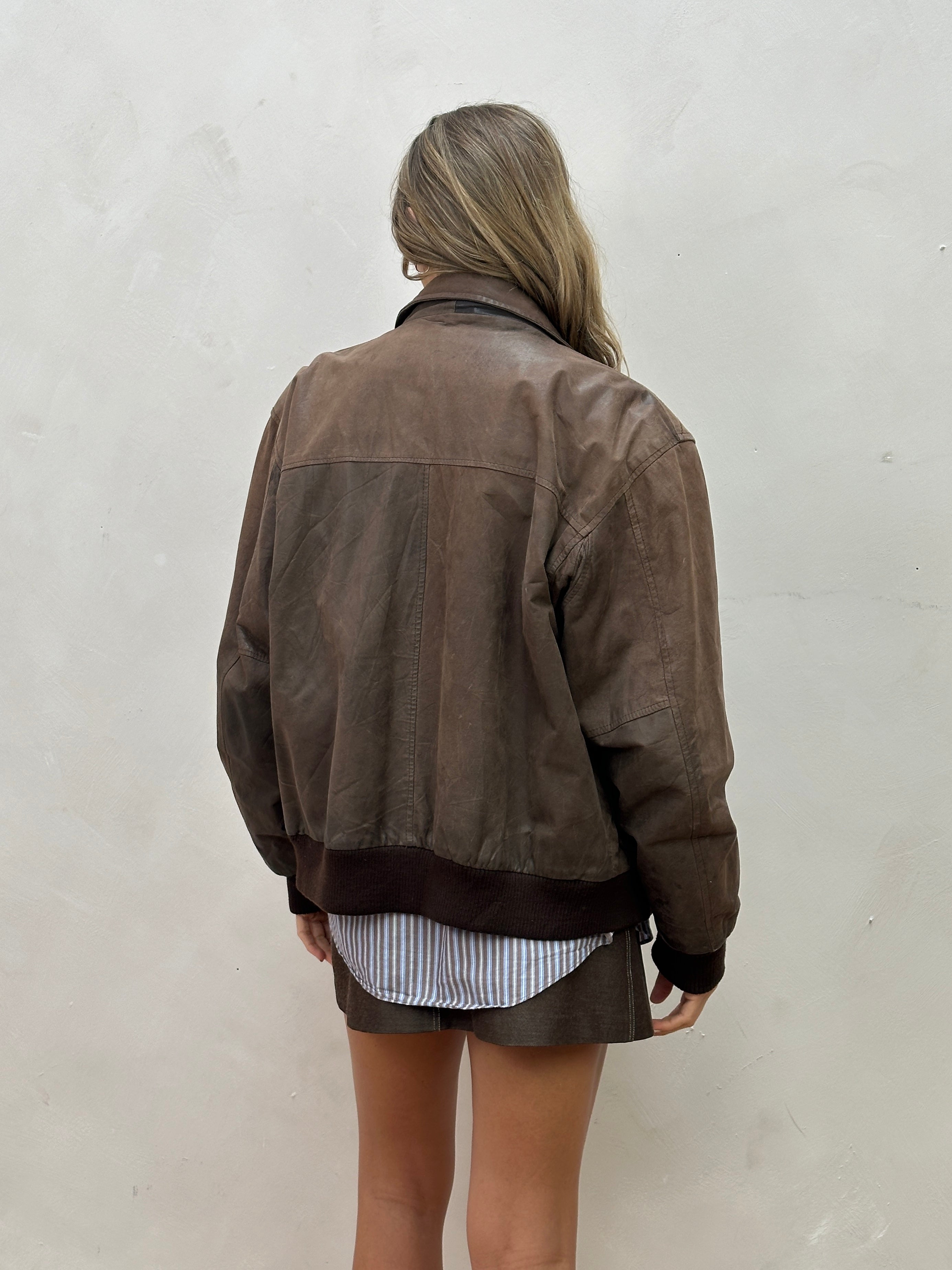 Vintage distressed leather bomber jacket in size large, featuring a rugged vintage style and classic design.