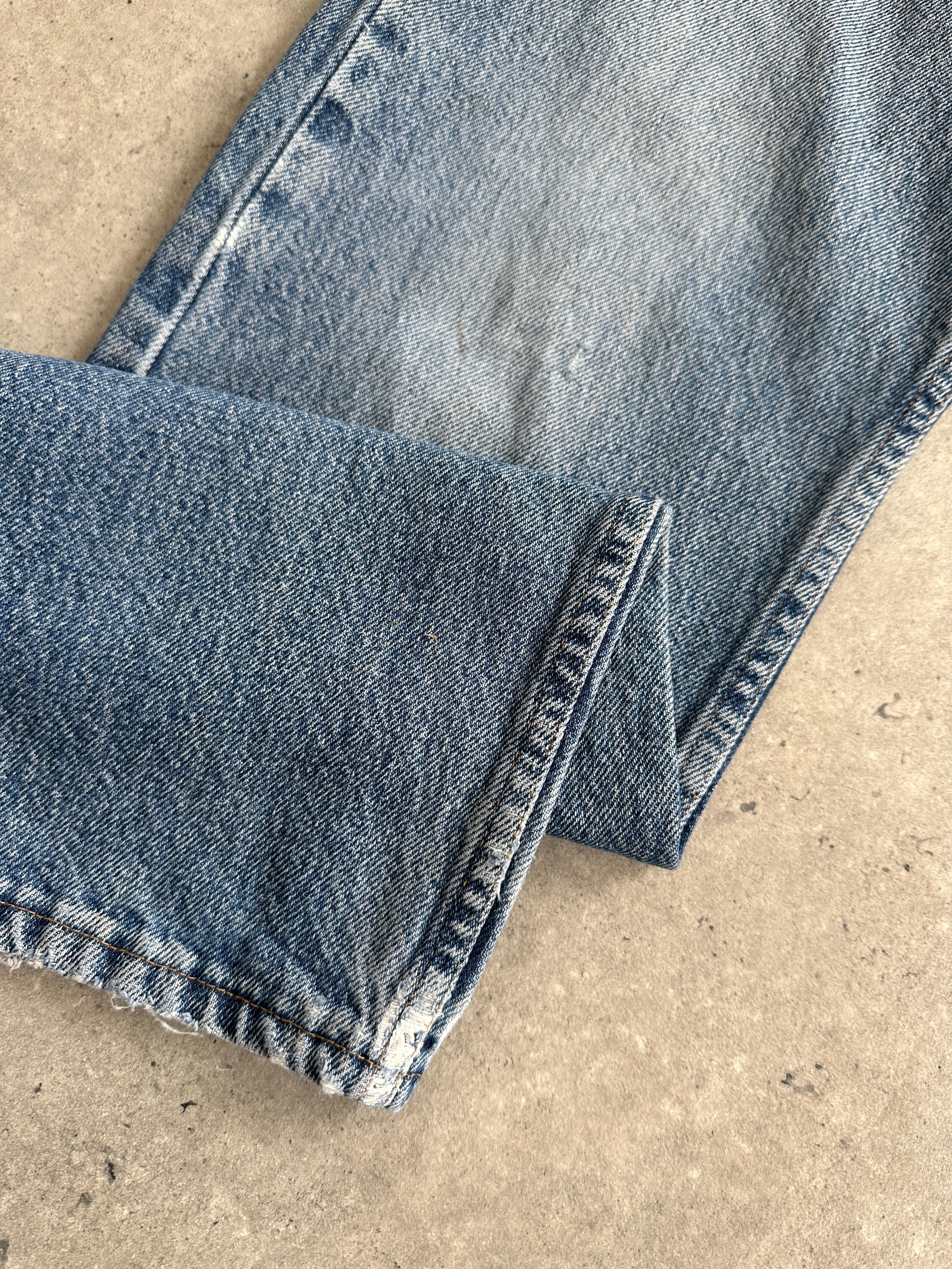 Wrangler mid wash straight leg high waisted denim jeans, front view with classic five-pocket design and belt loops.