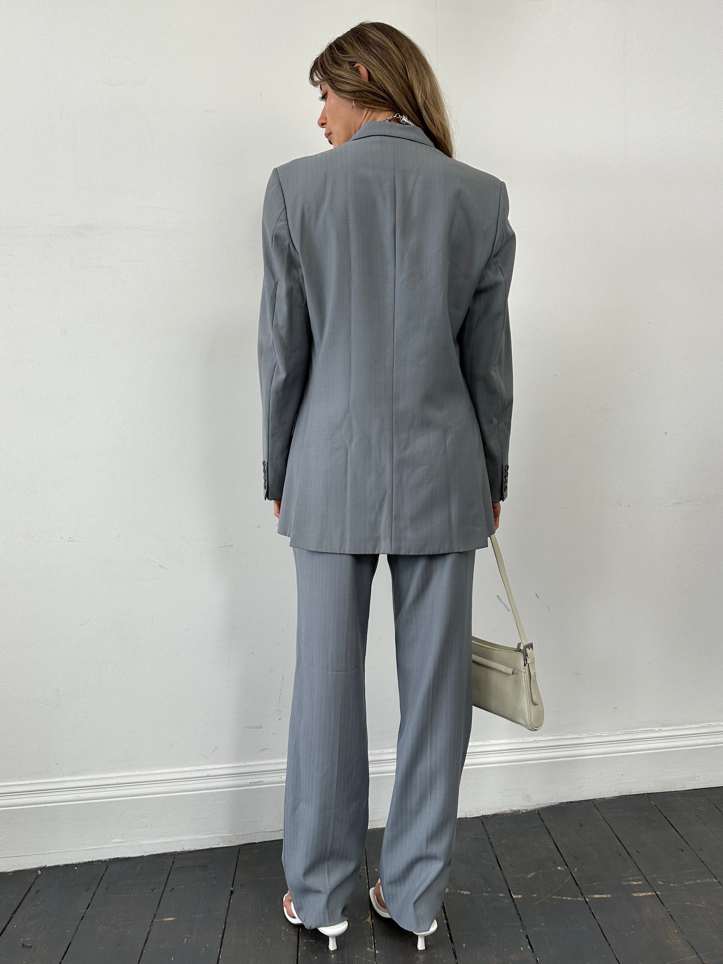 Christian Dior pure wool single-breasted suit jumpsuit in size 44R/W32, shown on a mannequin, tailored fit with lapel collar.
