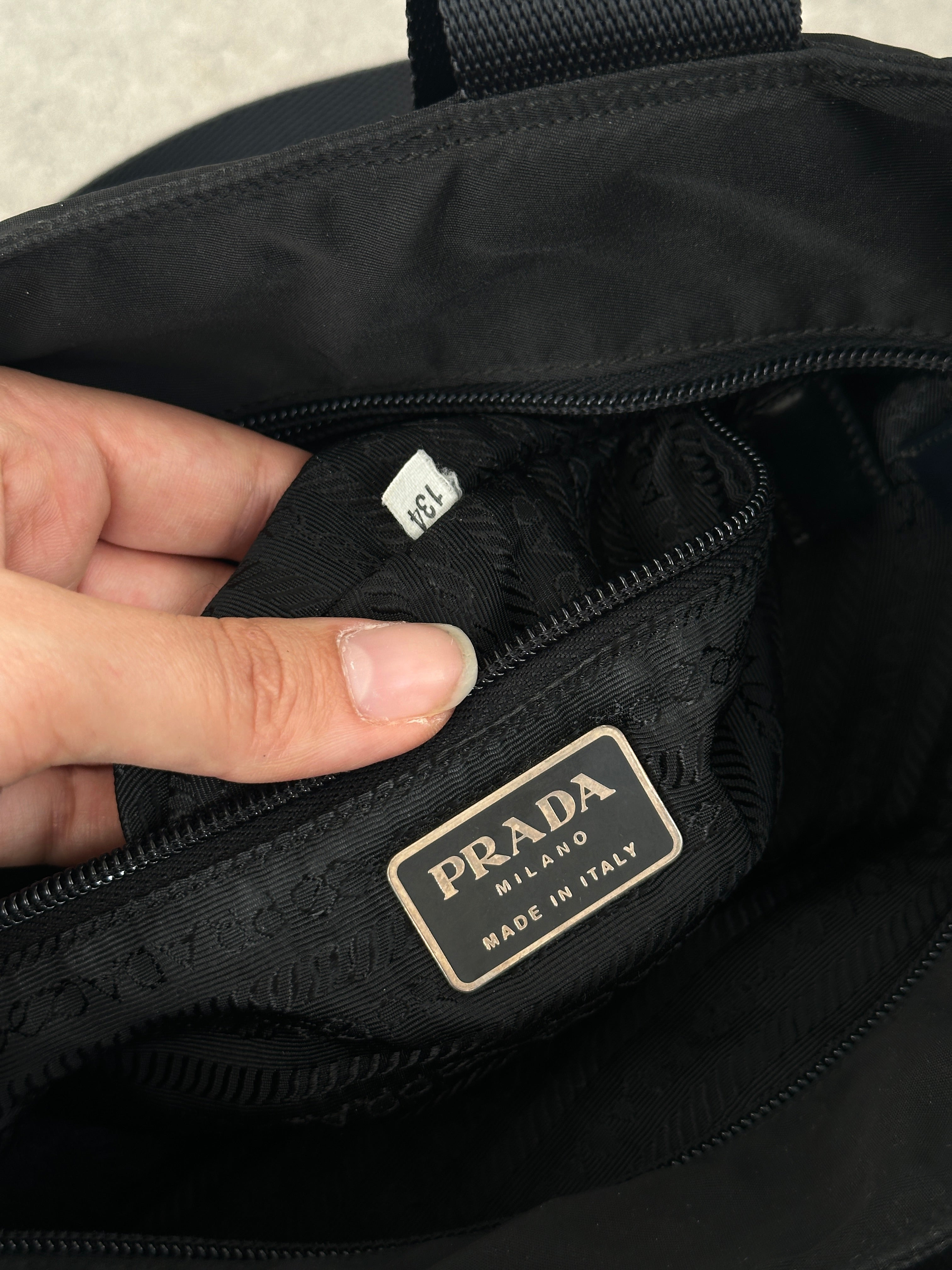 Prada 1997 nylon shoulder bag with adjustable strap and minimalist design, featuring the iconic Prada logo on the front.
