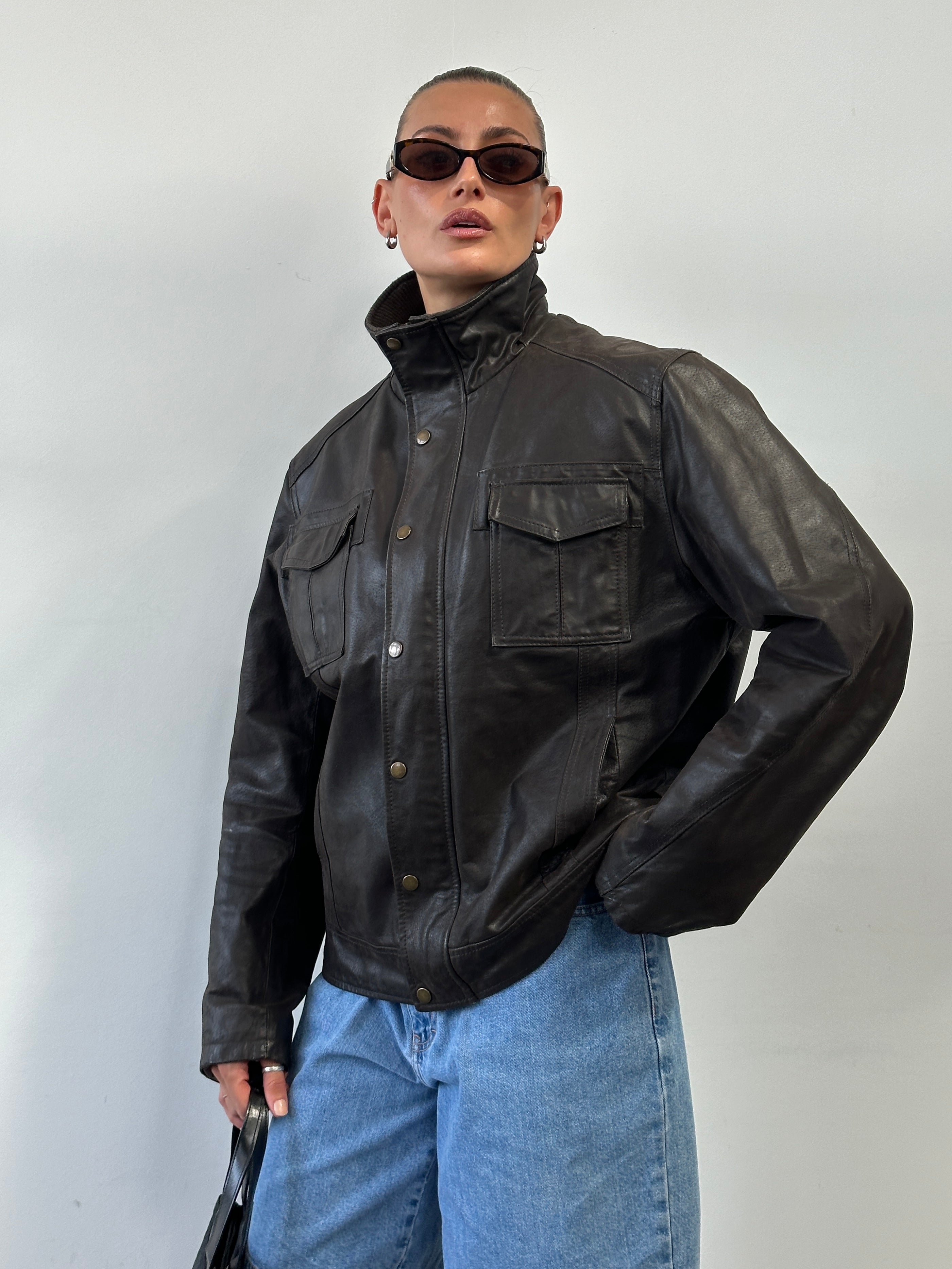 Vintage high neck leather jacket in XL, featuring classic design with textured leather and tailored fit, displayed on a hanger.