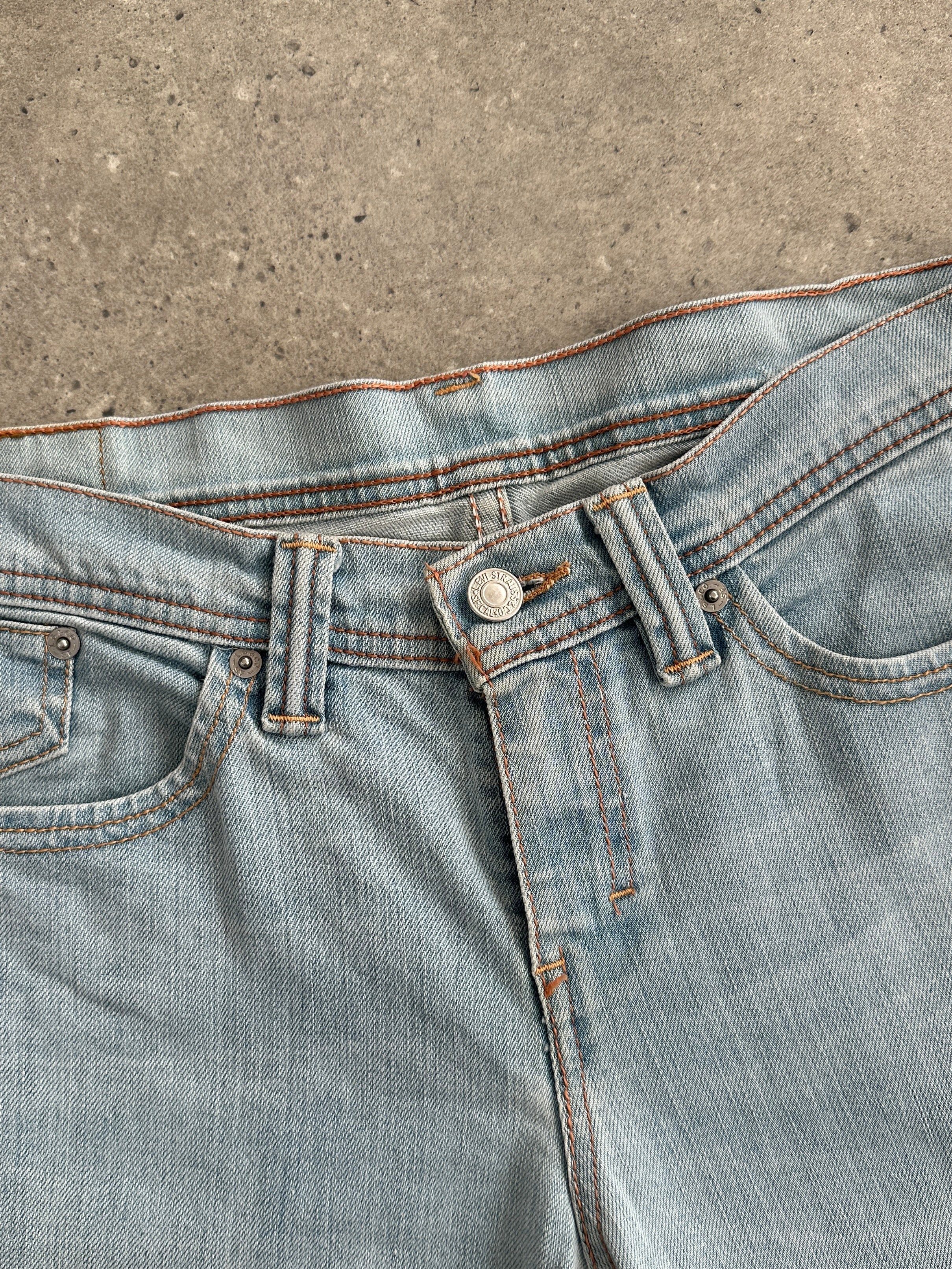 Levi’s low waist flared denim jeans in W28 displayed on a hanger, showcasing classic blue denim with a fitted waist and flared legs.
