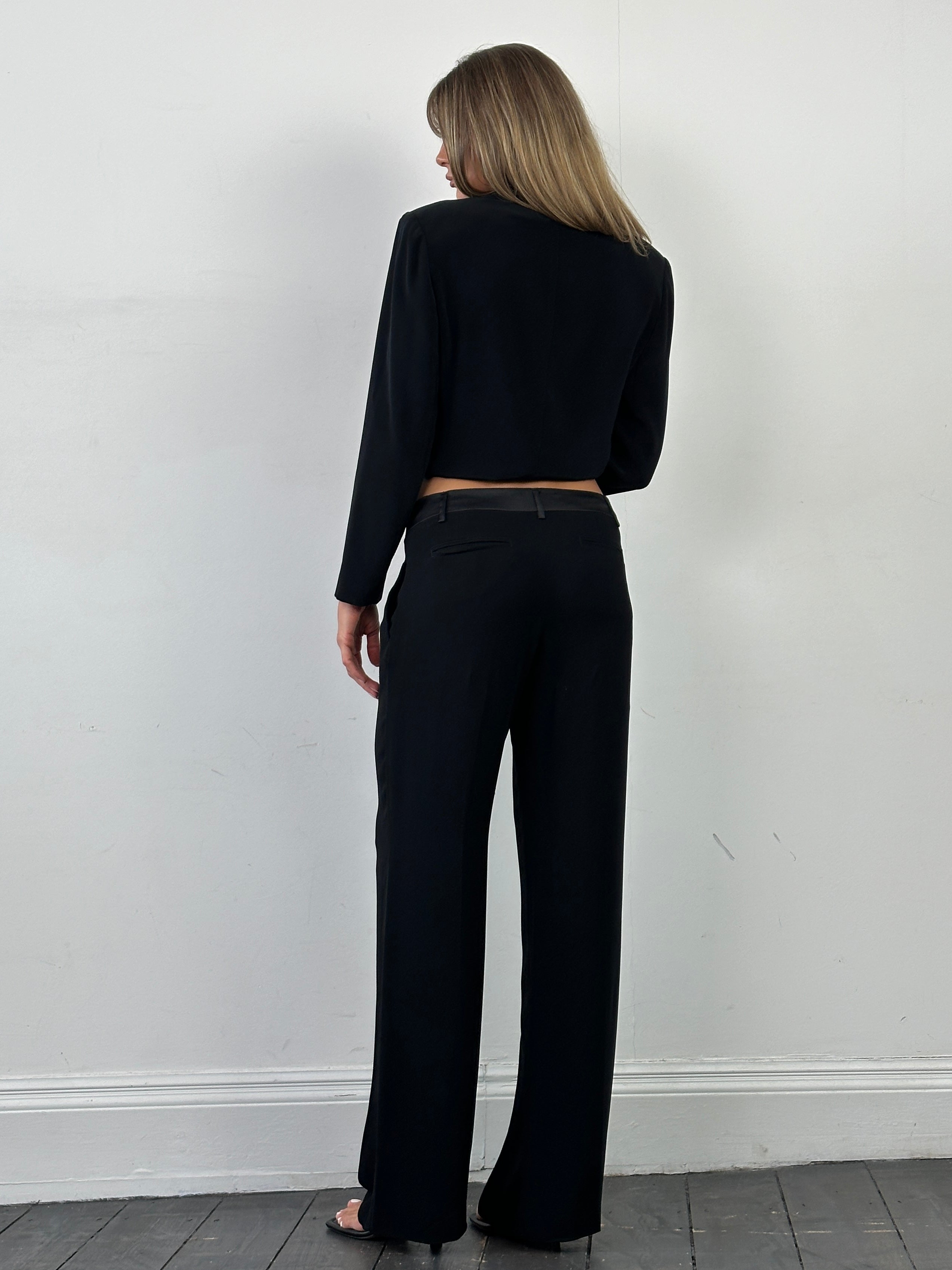 Valentino low waist wide-leg tuxedo trousers in black fabric, tailored fit, with belt loops and crease details.