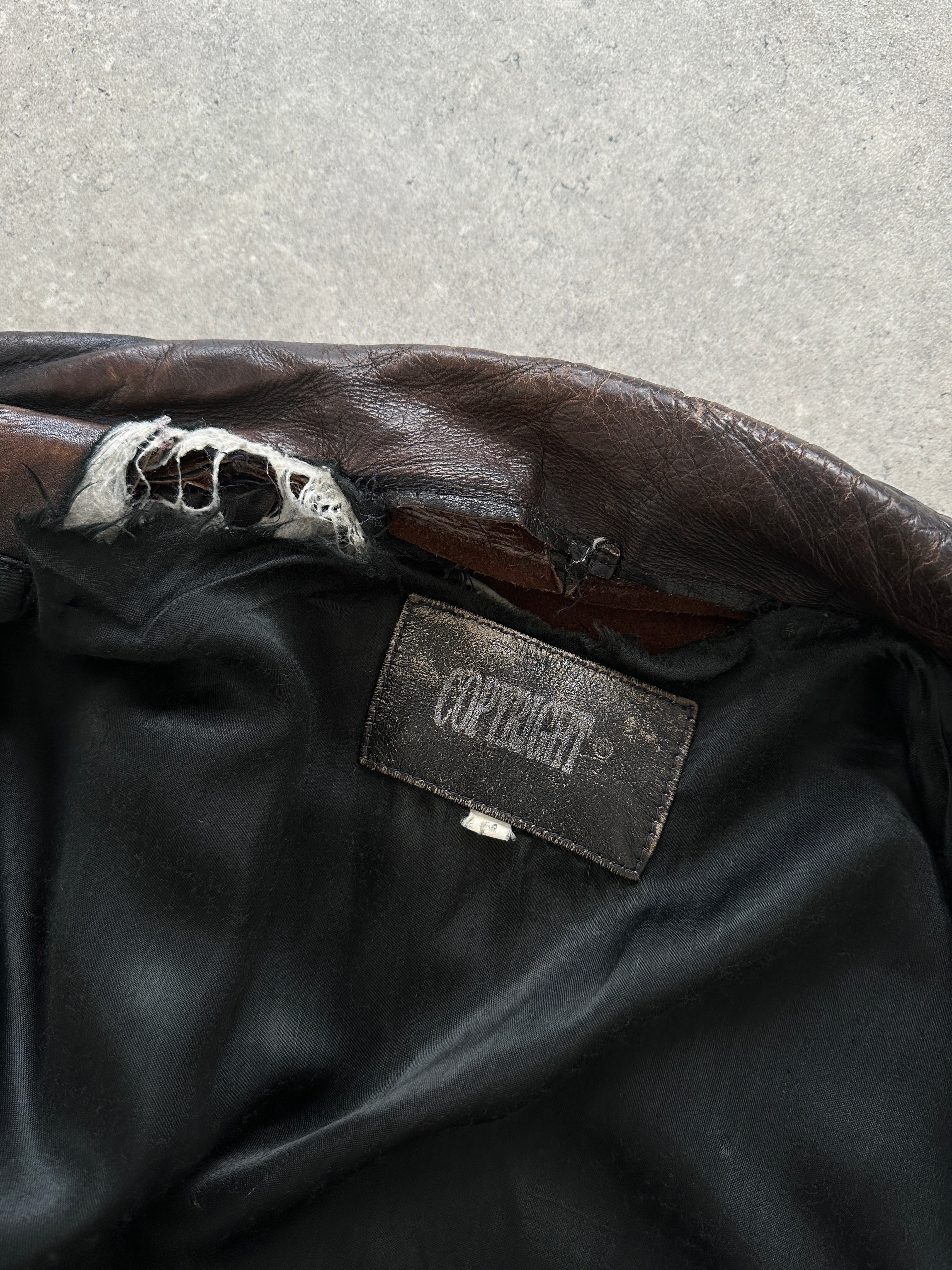 Vintage distressed leather jacket in size M/L, showcasing rugged texture and classic design with worn-in style.