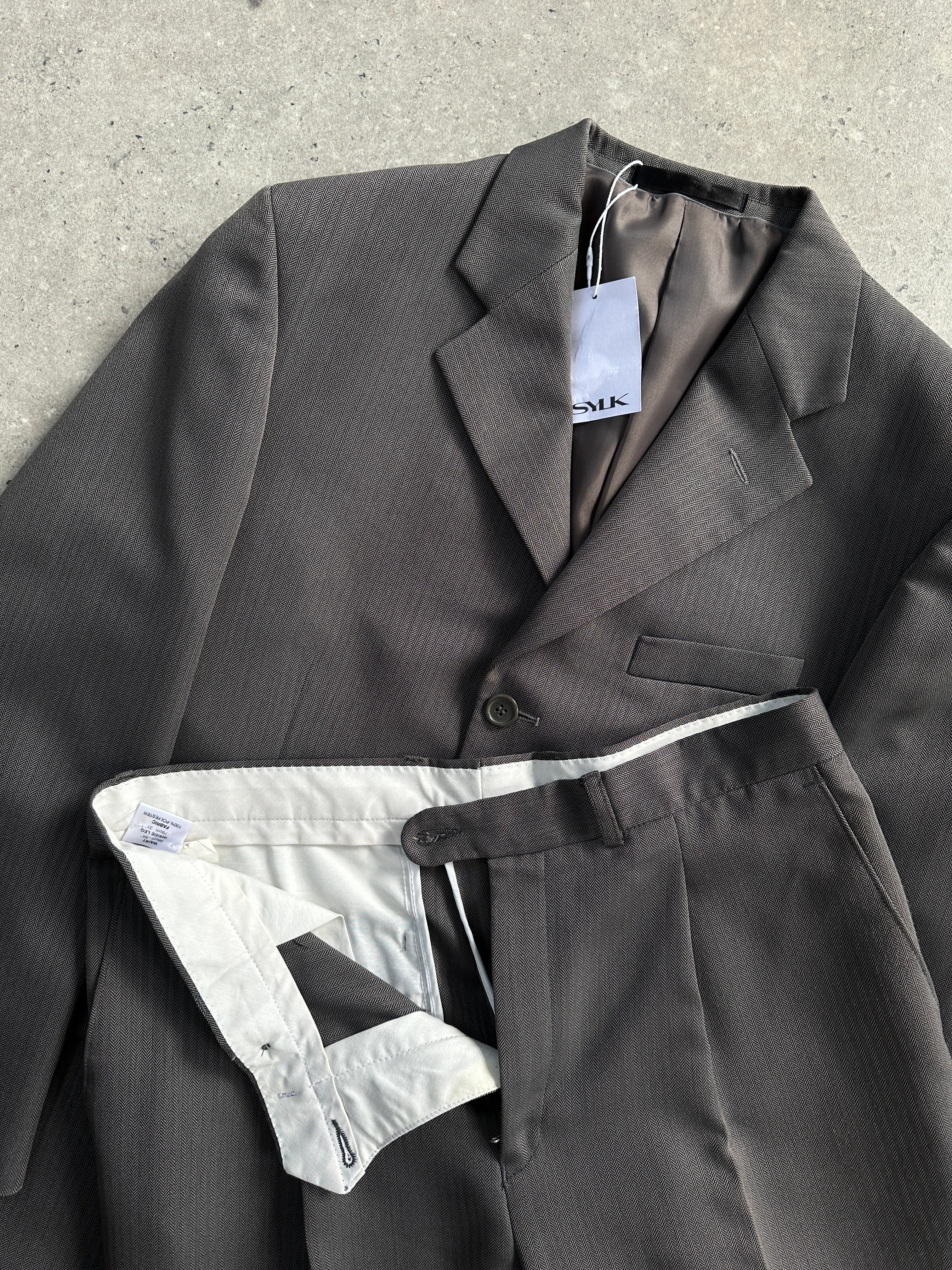 Vintage herringbone single-breasted suit jumpsuit in size 38R/W32, showing tailored fit and classic fabric pattern.