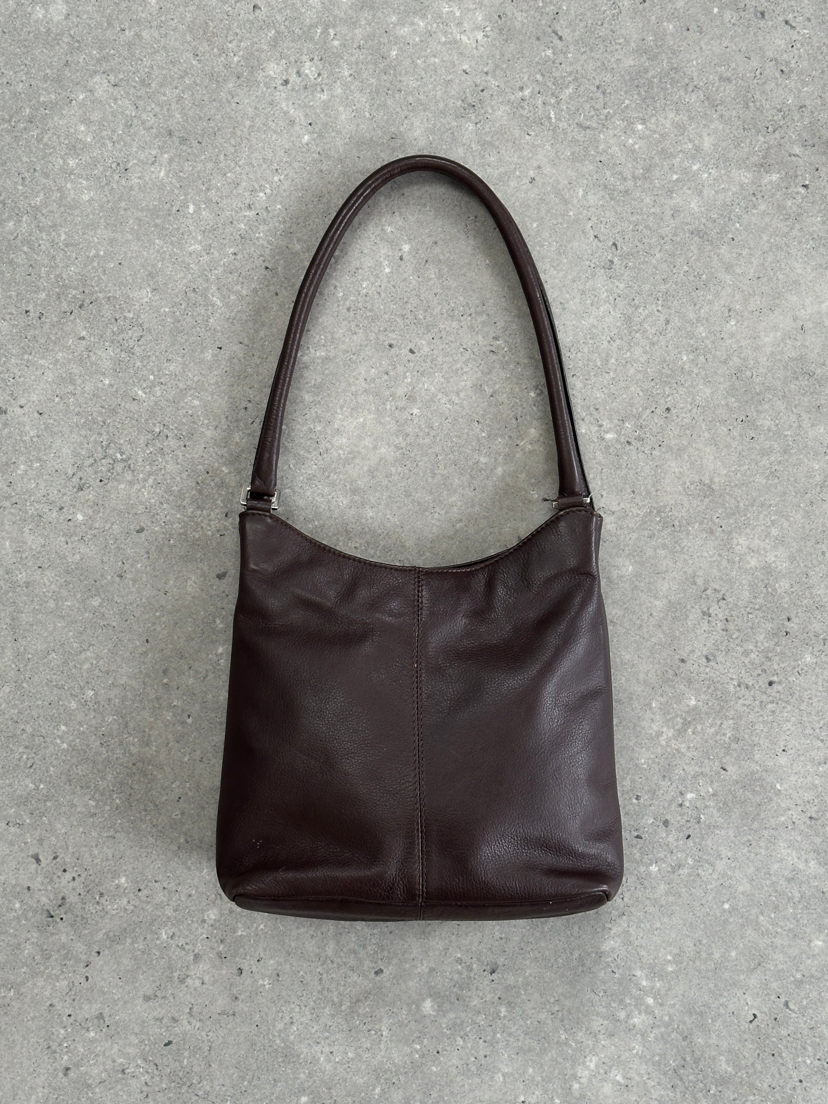 Vintage leather shoulder bag with adjustable strap, featuring classic design and durable craftsmanship.