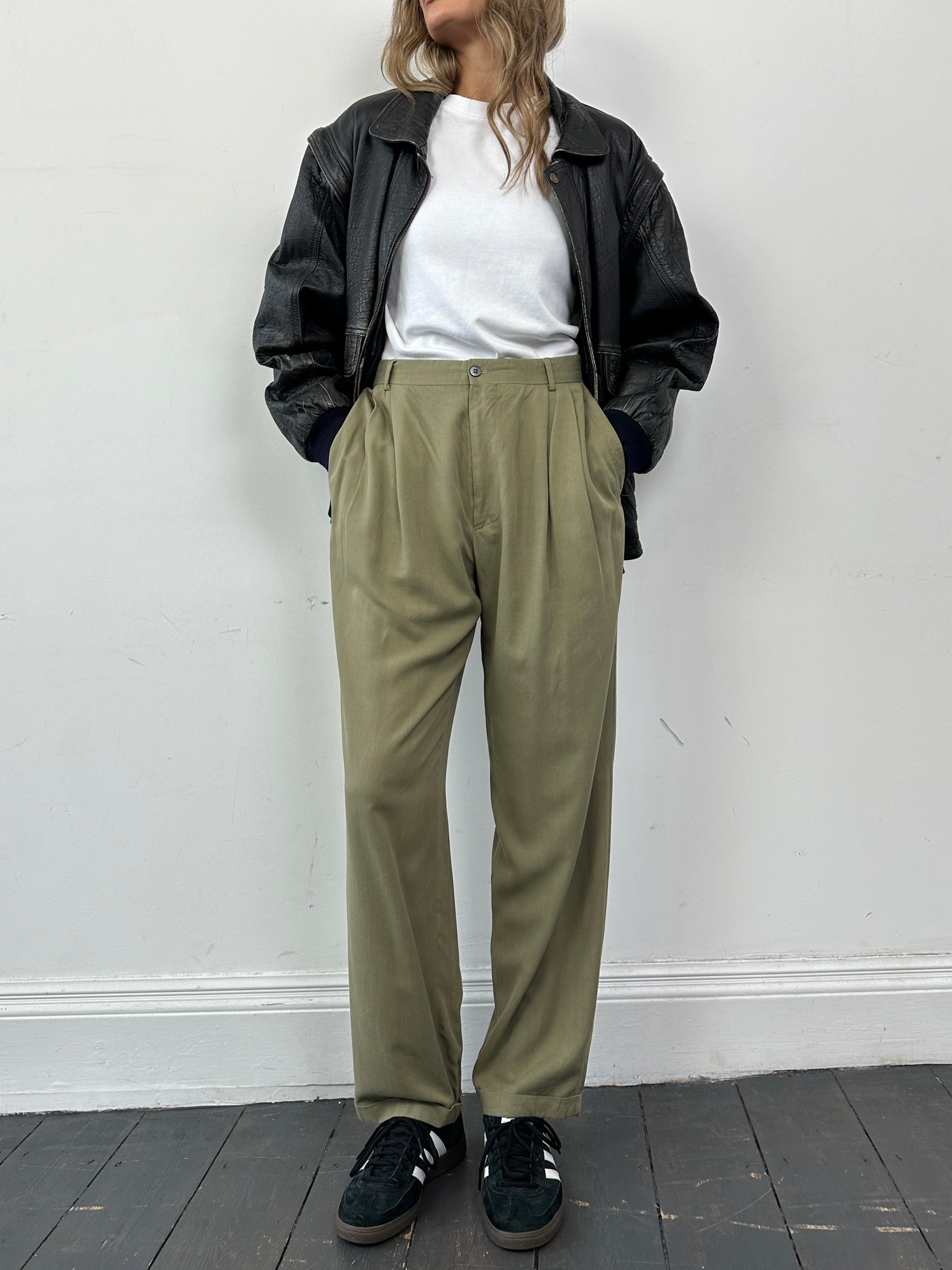 Versace Versus silk high-waisted straight-leg trousers in black, displayed on a hanger with visible waistband and tailored fit.