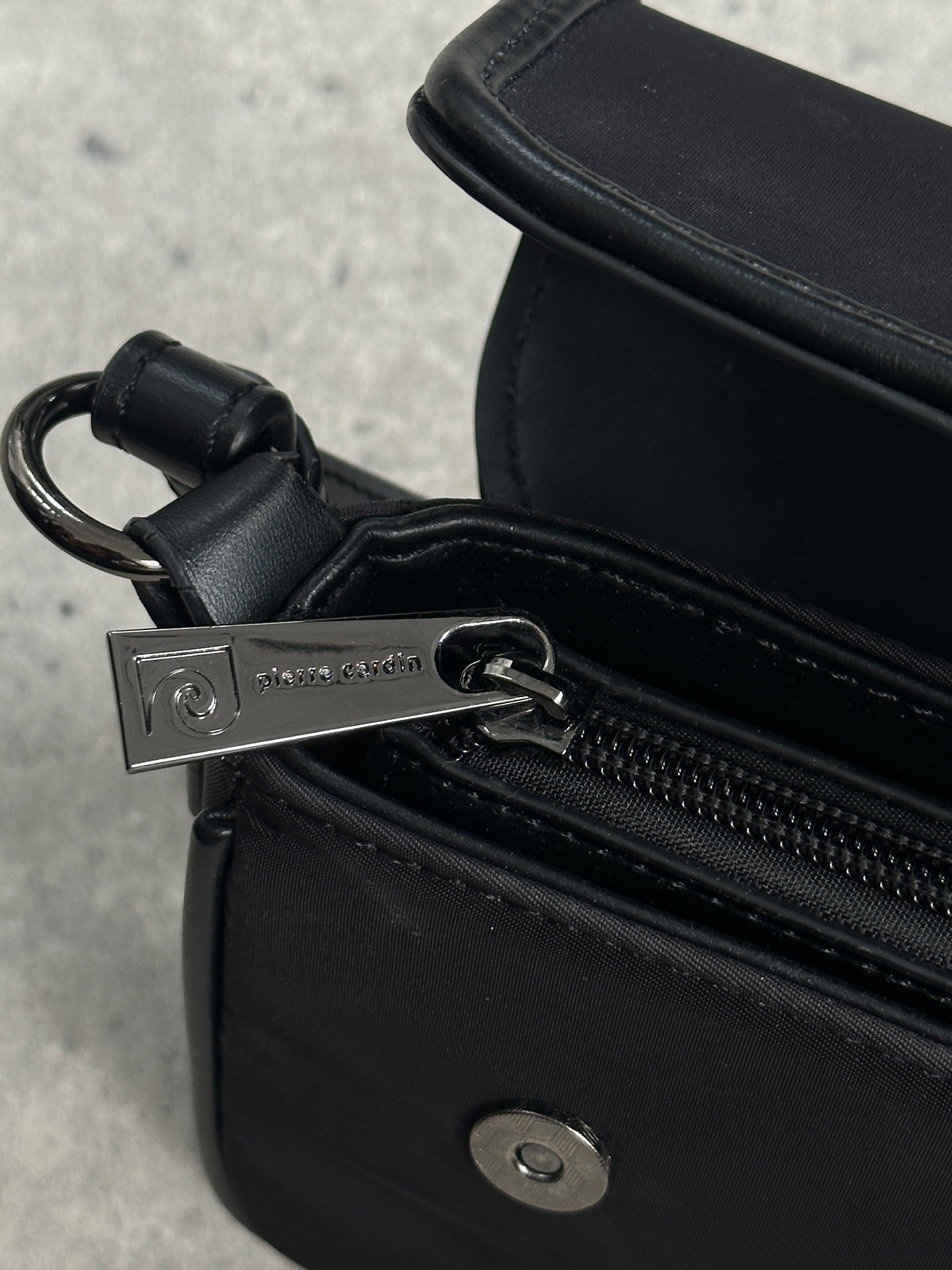 Pierre Cardin nylon hardware shoulder bag with adjustable strap and metal accents, stylish and functional accessory for everyday use.