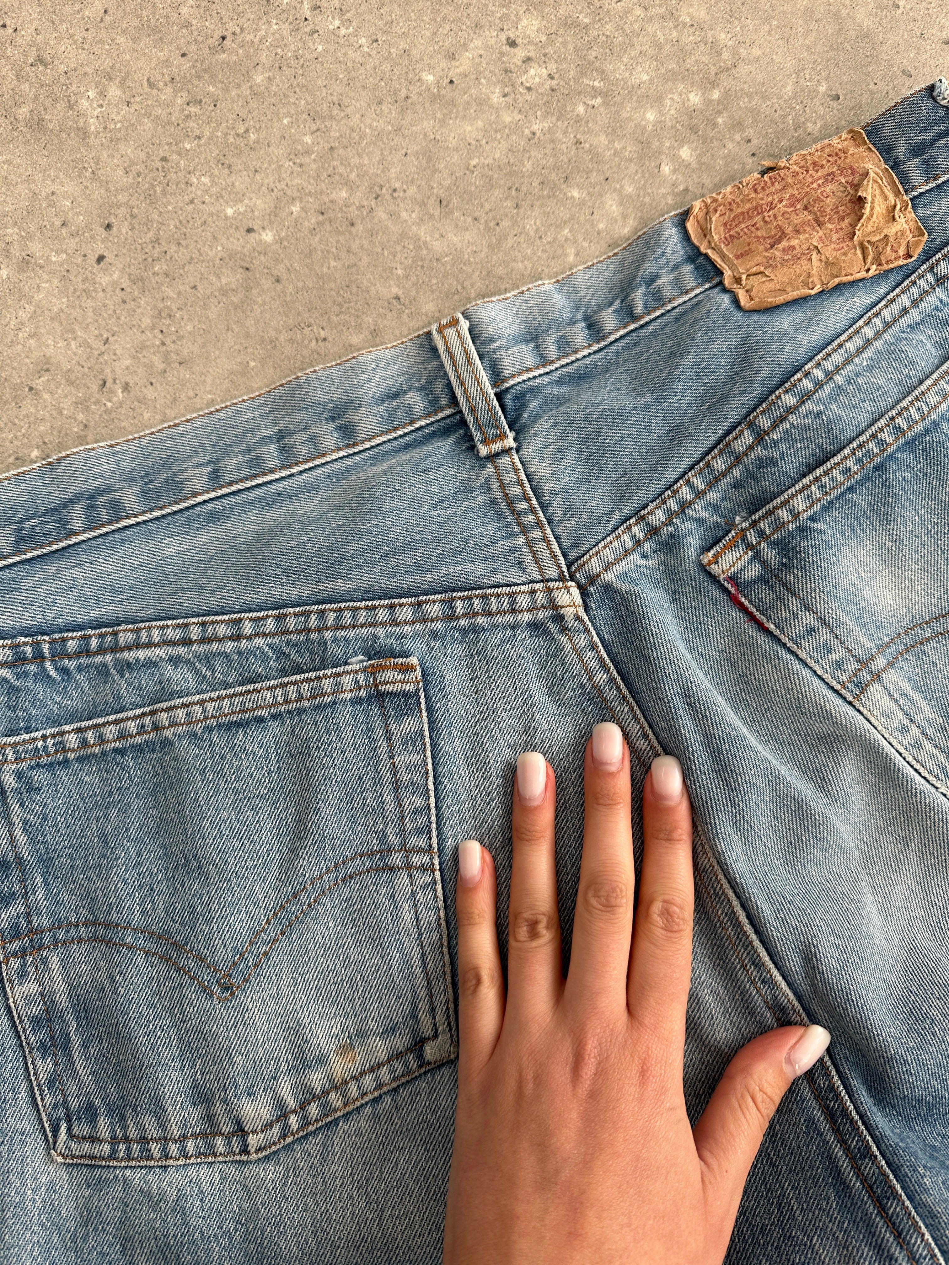 Levi’s faded straight leg denim jeans in size W32, showing classic blue jeans with a relaxed fit and distressed details.