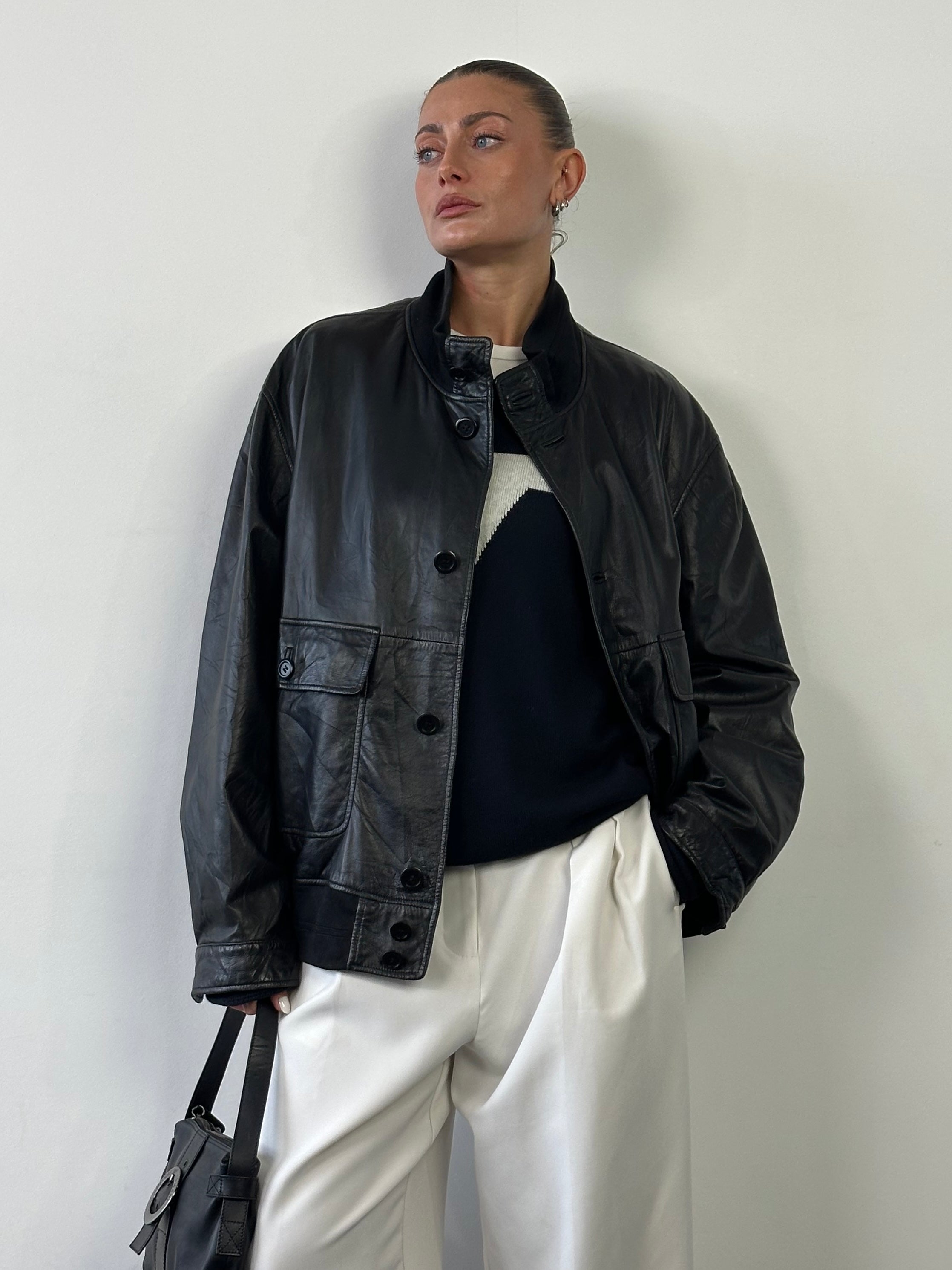 Hugo Boss leather bomber jacket in XL, with a sleek design, smooth black leather, and ribbed collar and cuffs.