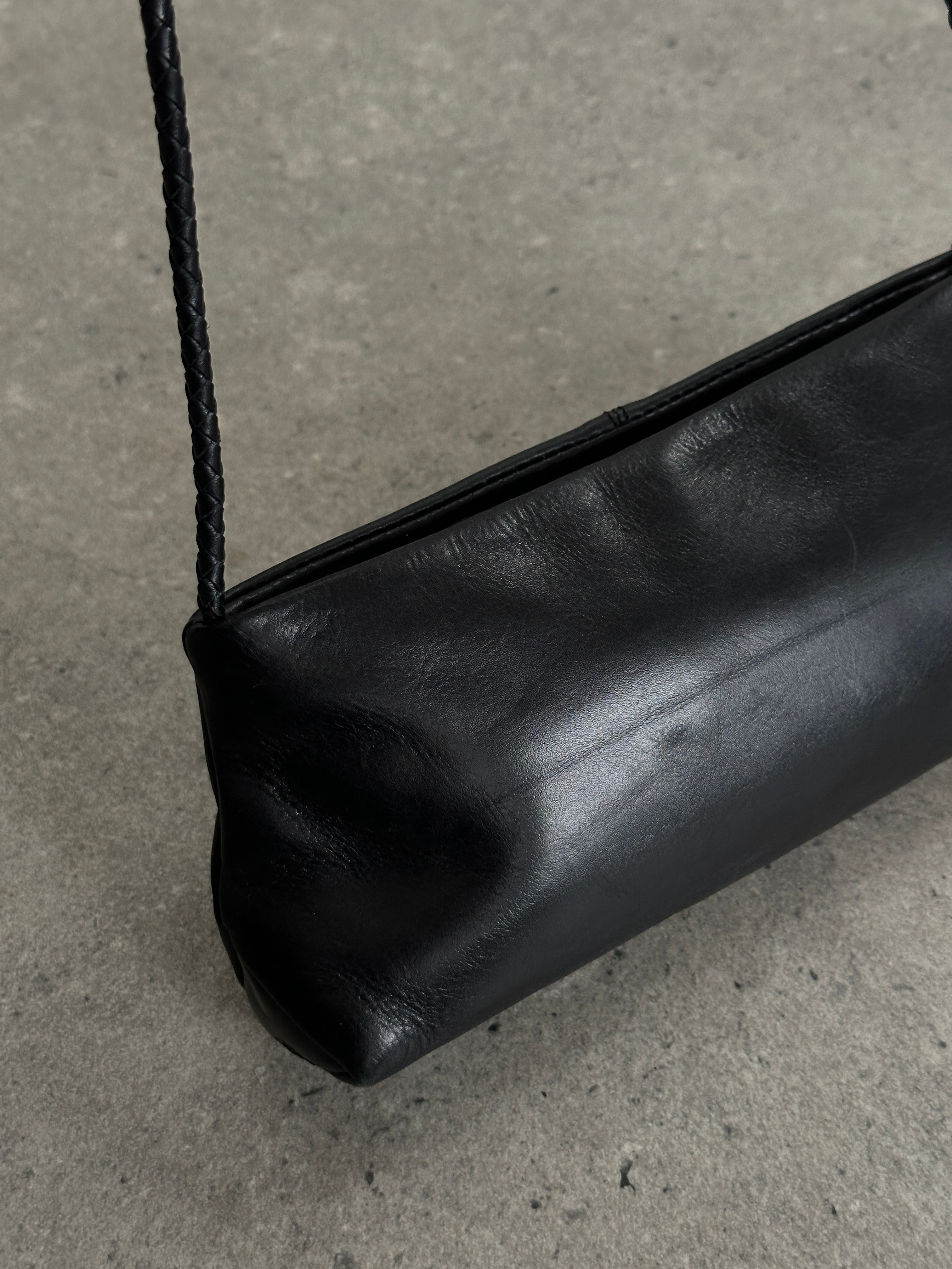 Vintage leather shoulder bag with adjustable strap, classic design, and aged finish, showcasing craftsmanship and timeless style.